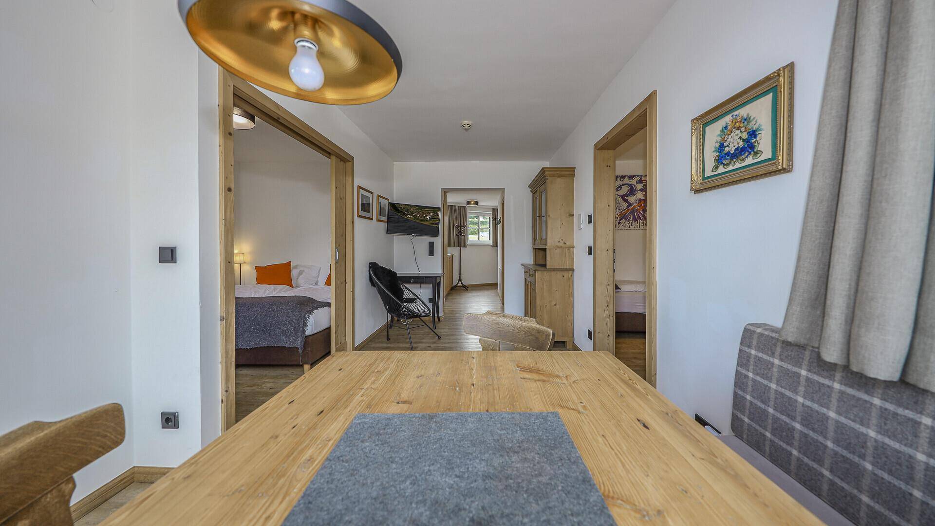 Flur mit Essbereich und Blick in angrenzende Zimmer, ausgestattet mit Holzmöbeln.
