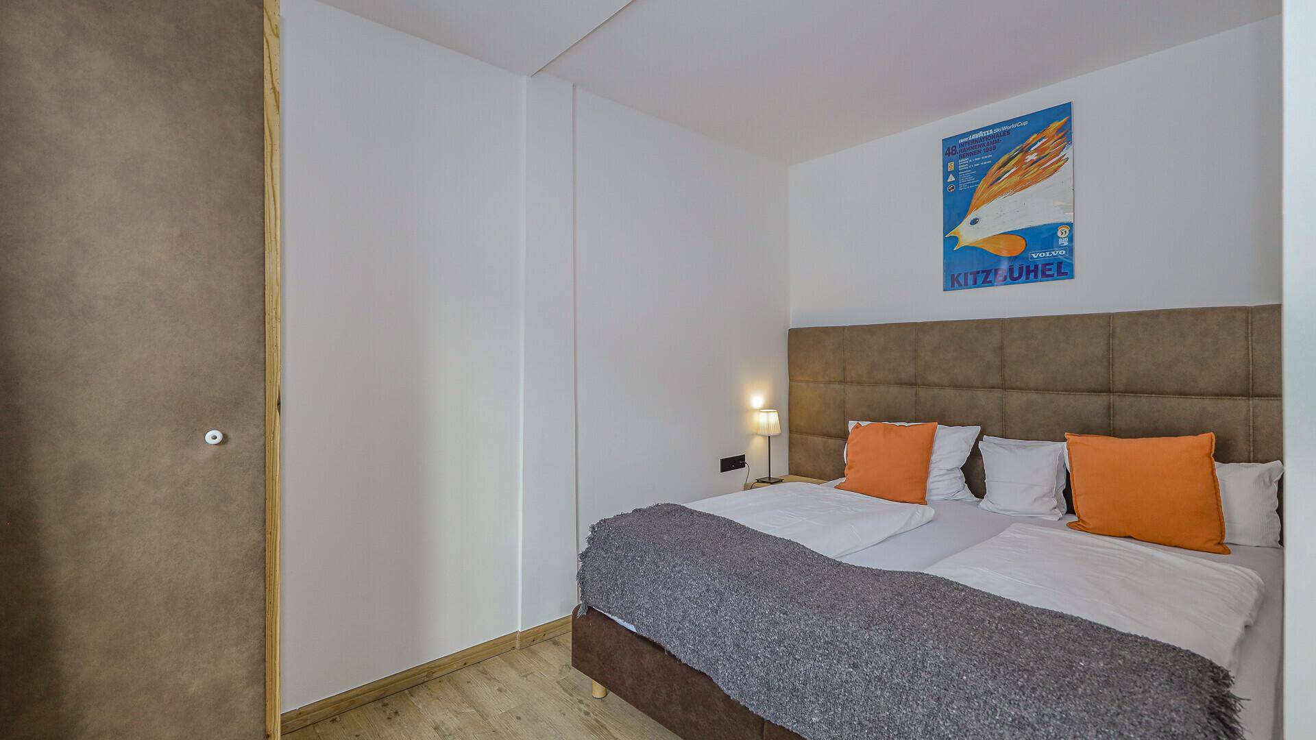 Gemütliches Schlafzimmer mit Doppelbett, Holzboden und einem dekorativen Bild an der Wand.