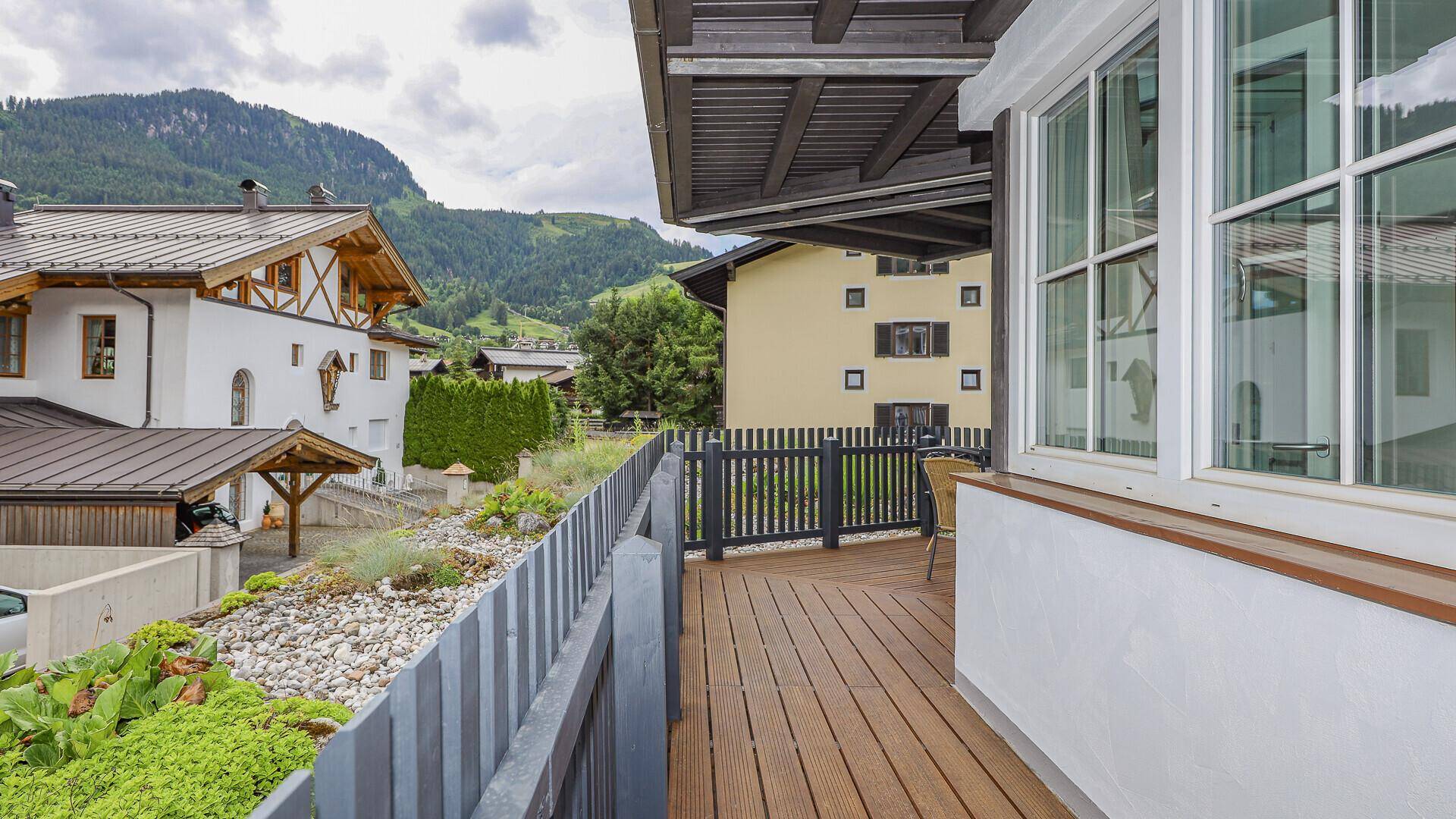 Geräumiger Balkon mit Holzboden und weitem Blick auf die alpine Landschaft.