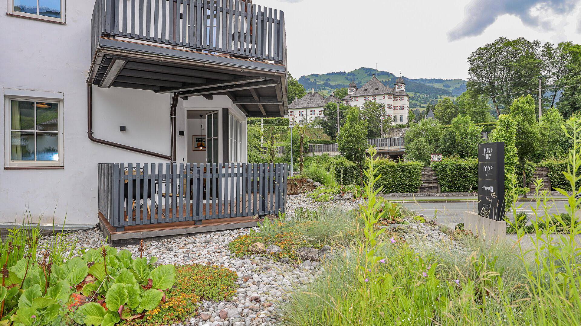 Gemütliche Terrasse im Erdgeschoss mit Sitzgelegenheiten und Blick auf die Umgebung.