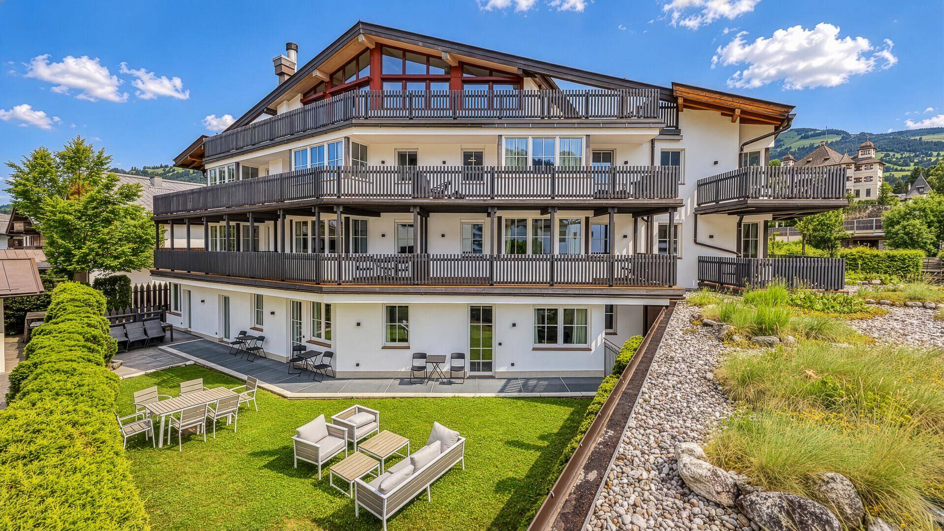 Gepflegter Gartenbereich mit Rasenfläche und modernen Outdoor-Sitzmöbeln.