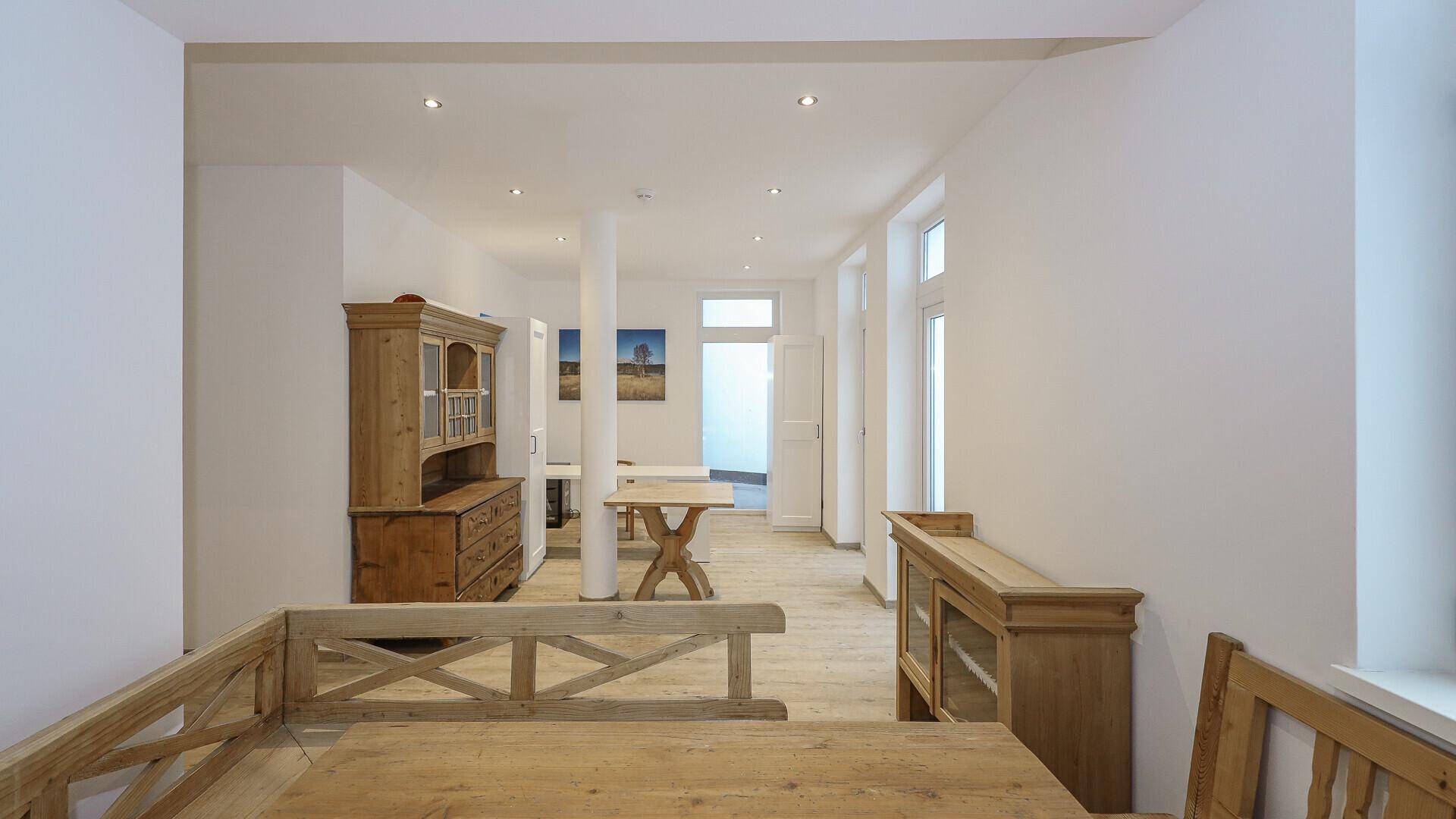 Großer Wohnbereich mit Holzboden, traditionellen Möbeln und hellem Ambiente.