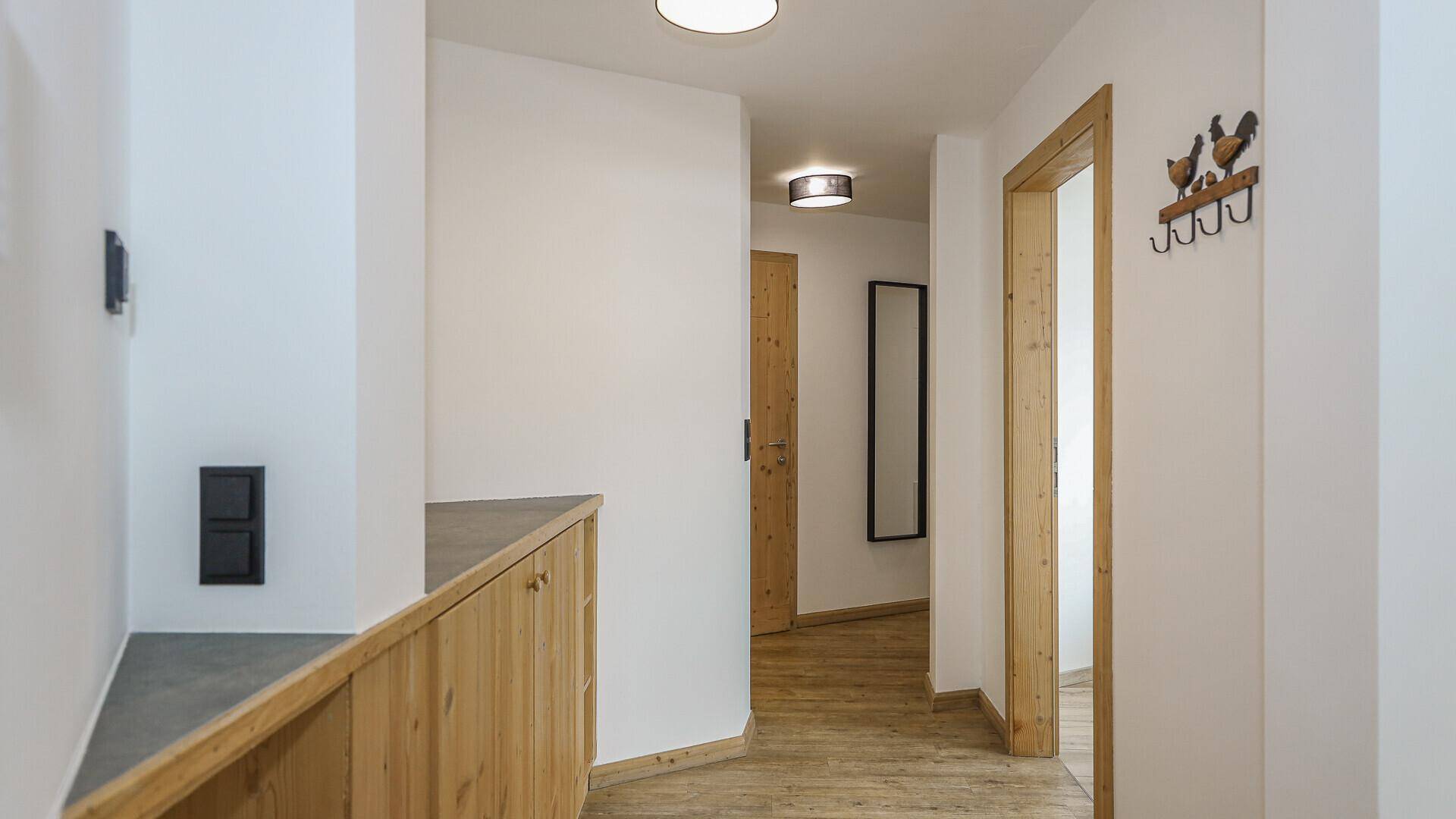 Geräumiger Flur mit Holzboden, Einbauschrank und Garderobe.