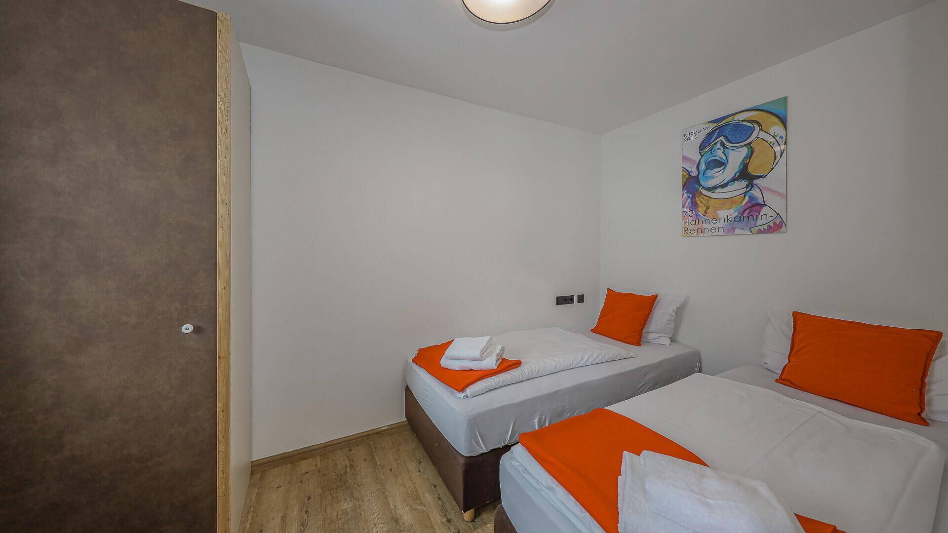 Helles Schlafzimmer mit zwei Einzelbetten und farbenfrohen Akzenten an den Wänden.