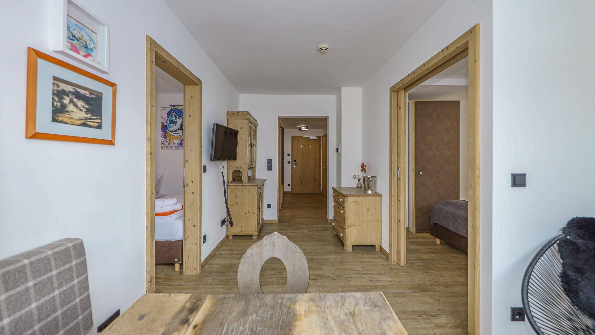 Langer Flur mit Holztüren und traditionellen Möbeln, der zu weiteren Zimmern führt.
