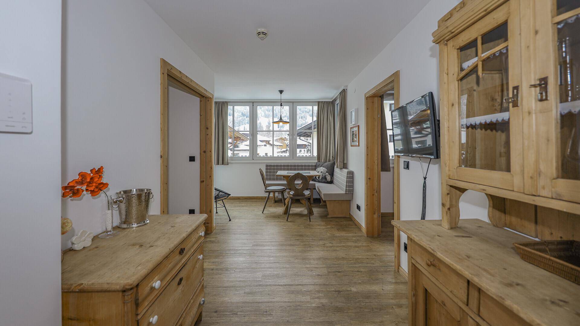 Gemütlicher Eingangsbereich mit traditionellen Holzmöbeln und Blick in den Essbereich.