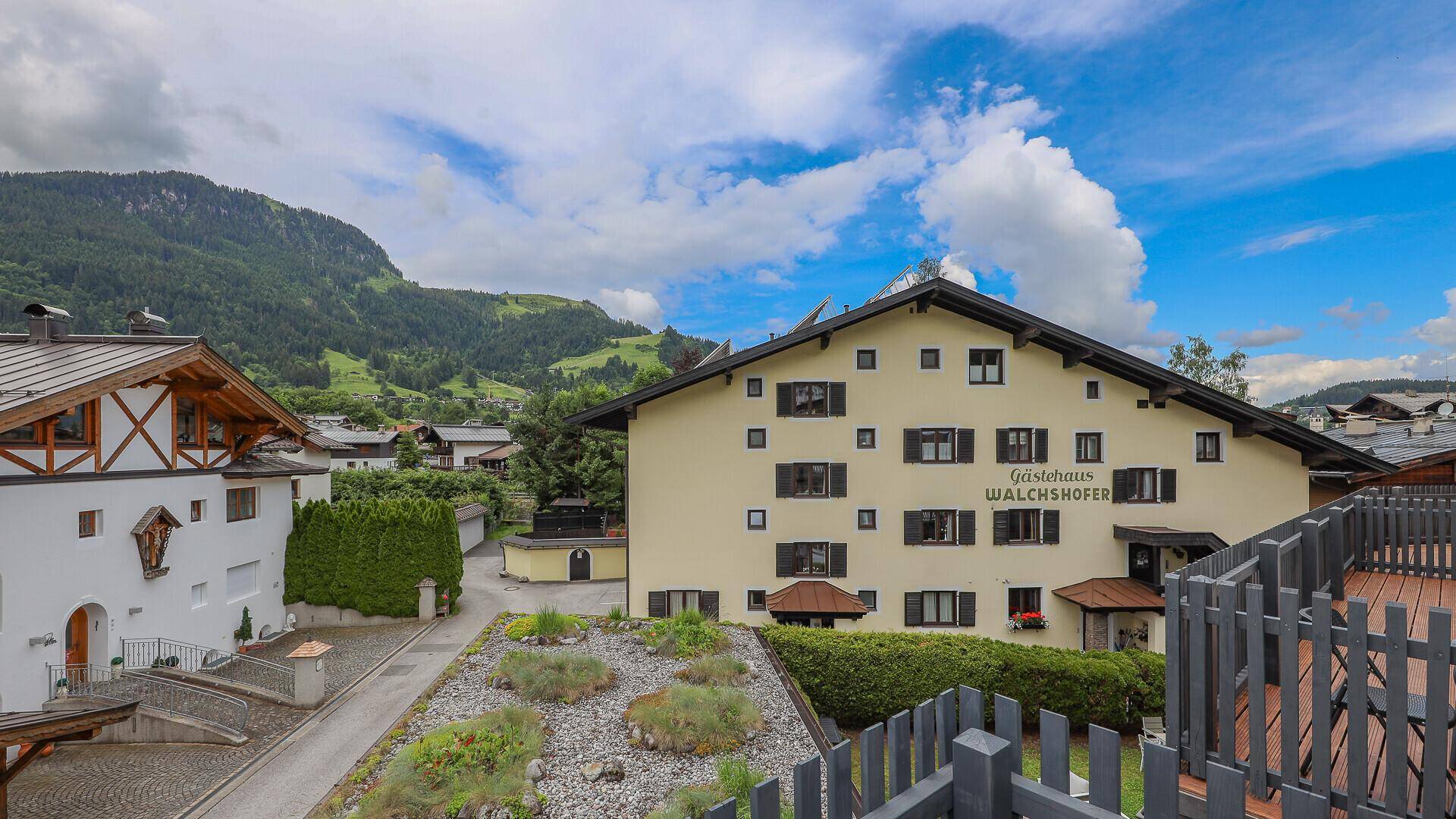 Blick auf die umliegende alpine Architektur und die grüne Berglandschaft.