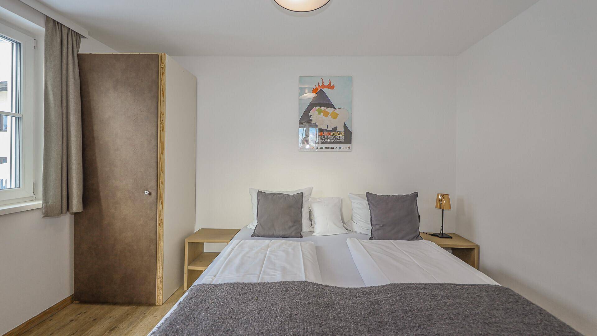 Gemütliches Schlafzimmer mit Doppelbett, Nachttischen und schlichtem Design.