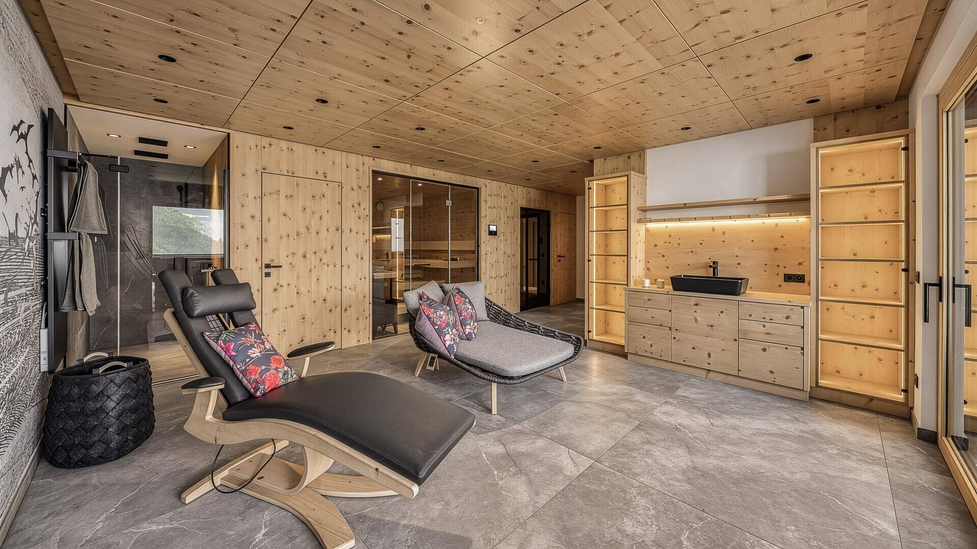 Entspannender Wellnessbereich mit Liegen, Sauna und Holzelementen.