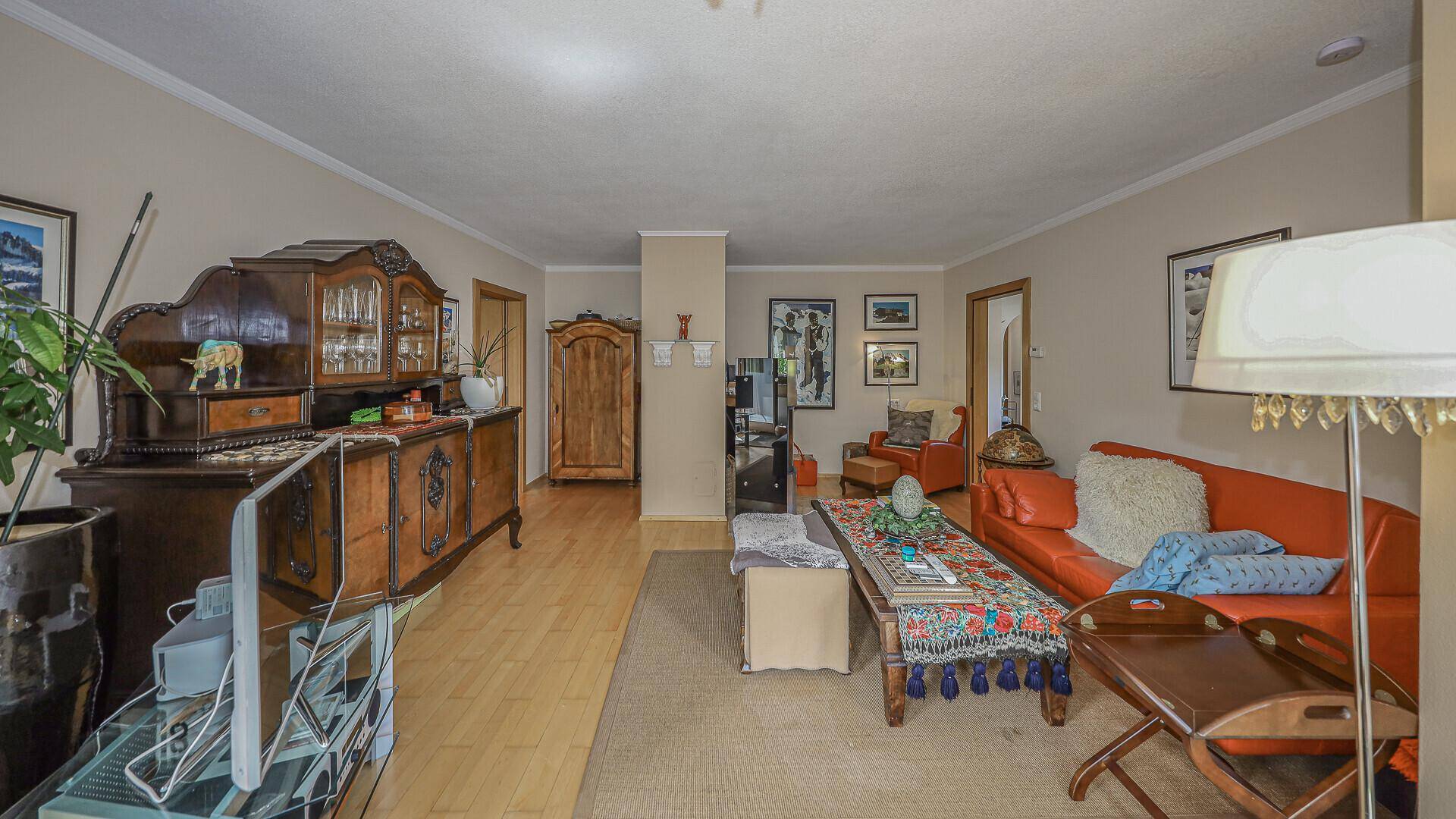 Geräumiges Wohnzimmer mit traditionellen Holzmöbeln und hellem Holzboden.