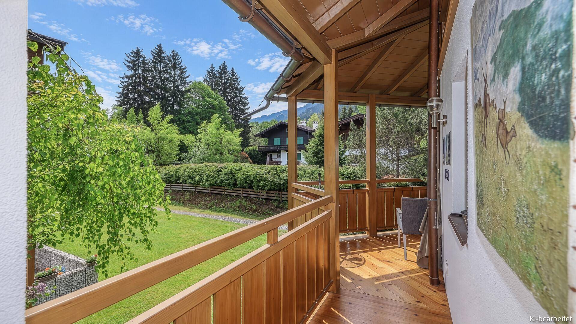 Geräumiger Holzbalcon mit schöner Aussicht auf die Berge und grüne Umgebung.