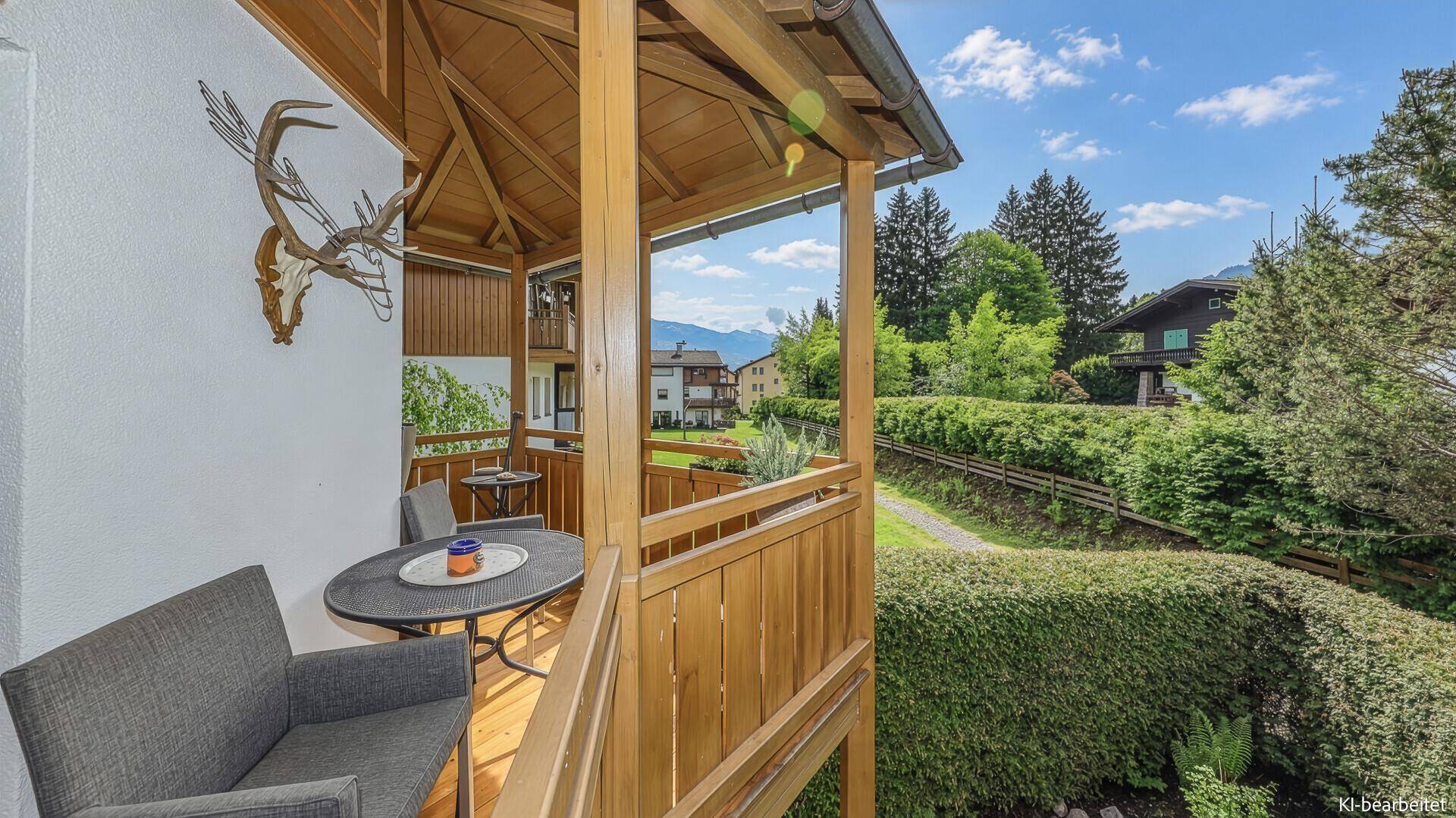 Gemütlicher Holzbalcon mit Sitzgelegenheiten und weitem Blick auf die Berglandschaft.