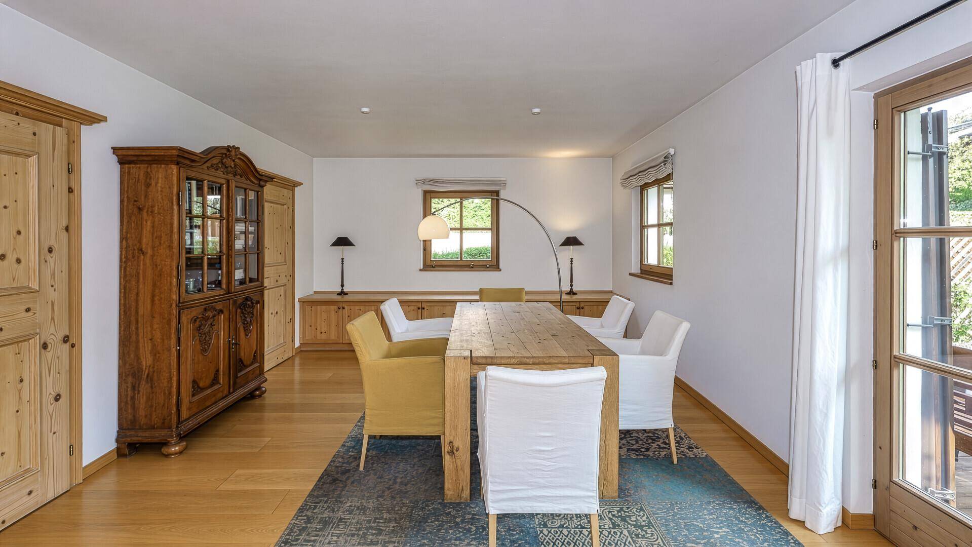 Essbereich mit großem Holztisch, traditionellem Schrank und Zugang zur Terrasse.