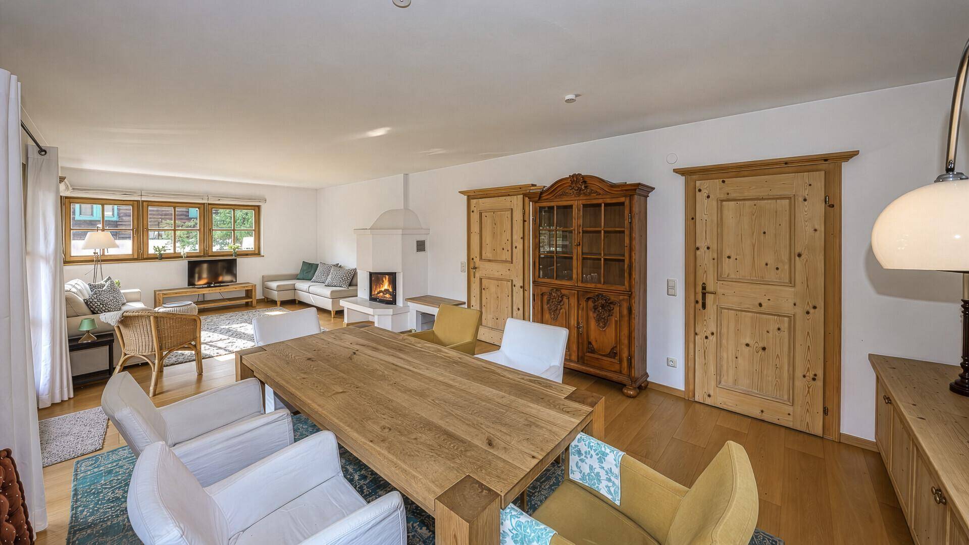 Heller Wohn- und Essbereich mit Holztisch, Kamin und traditionellen Möbeln.