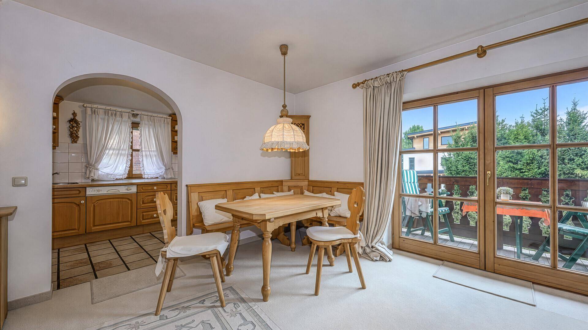 Essbereich mit traditioneller Eckbank, Holztisch und Zugang zum Balkon.