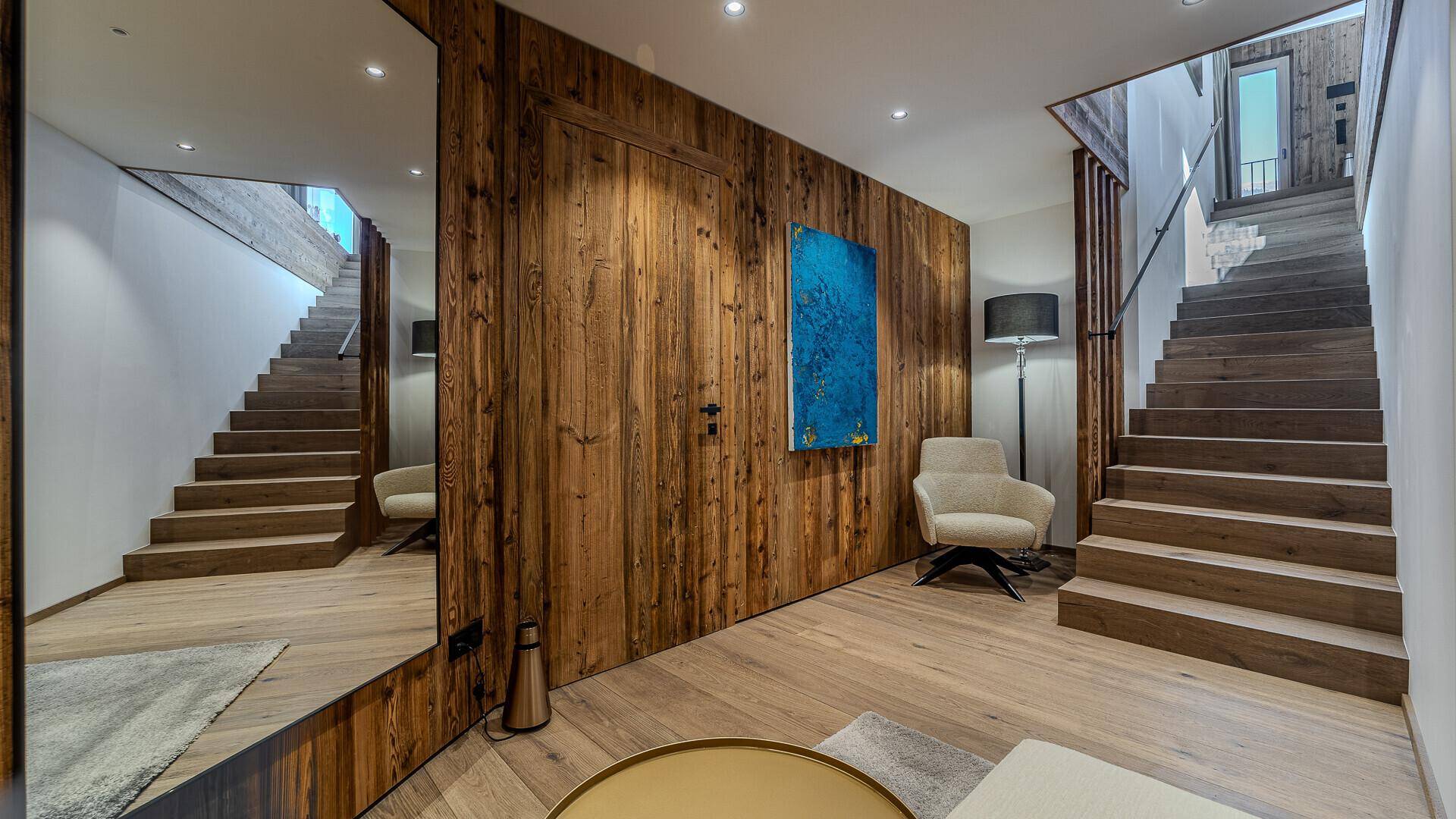 Heller Eingangsbereich mit Holzboden, Holzwänden und einer eleganten Holztreppe.
