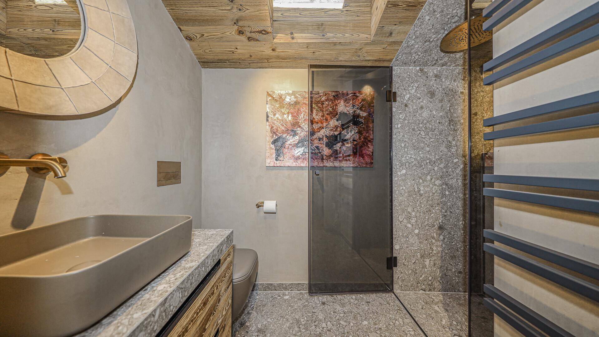 Modernes Badezimmer mit Einzelwaschbecken, Duschkabine und beheiztem Handtuchhalter.