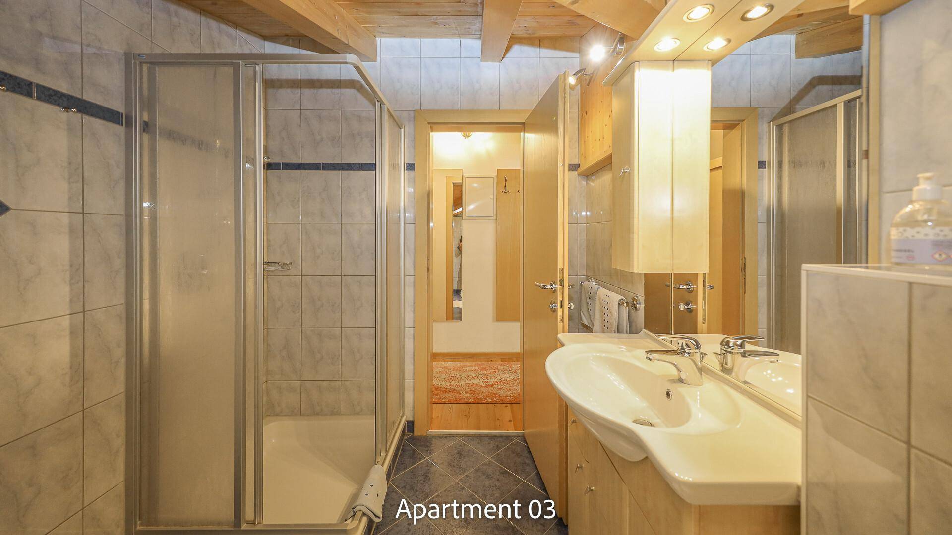 Modernes Badezimmer mit Dusche, Waschbecken und Spiegelschrank unter Dachschräge.