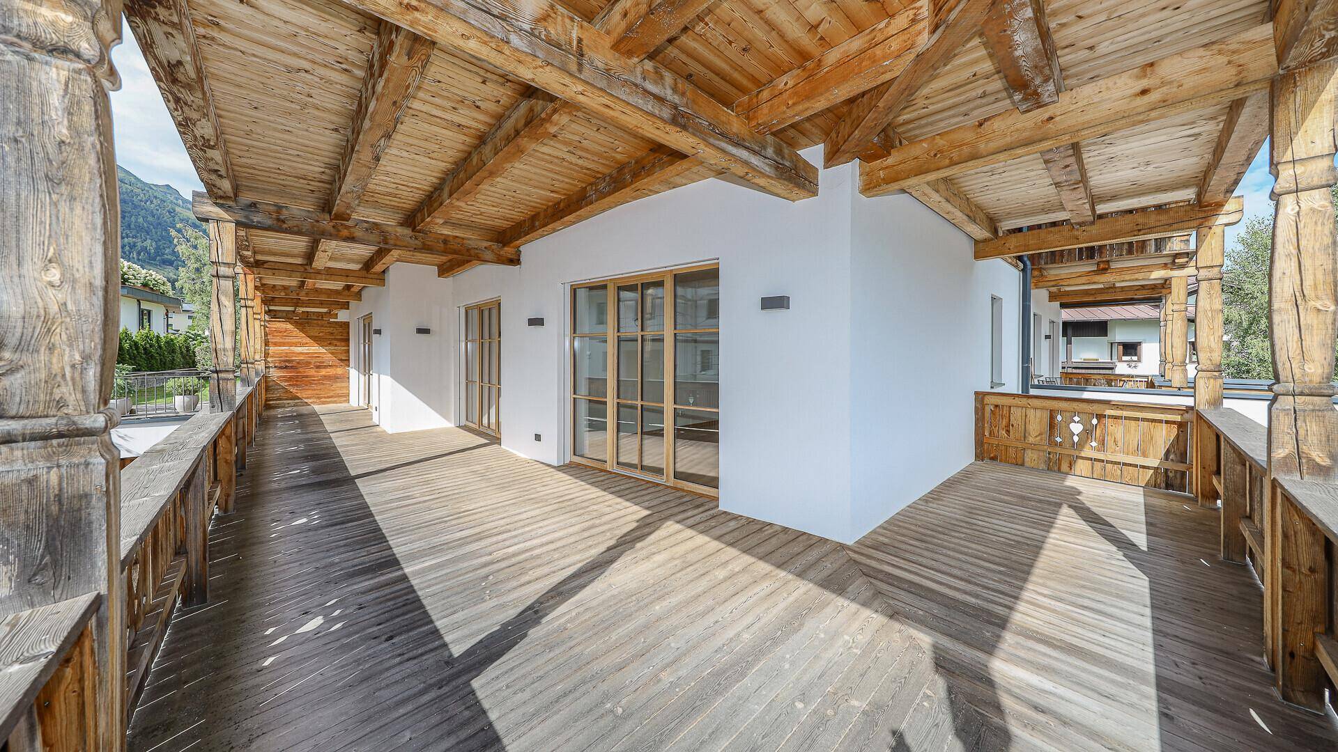 Langer Holzbalkon mit viel Platz und Blick auf die Umgebung.