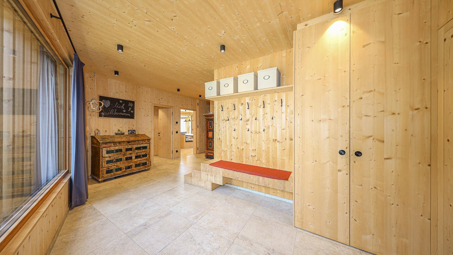 Praktischer Eingangsbereich mit Garderobe, Sitzbank und integrierten Schränken.