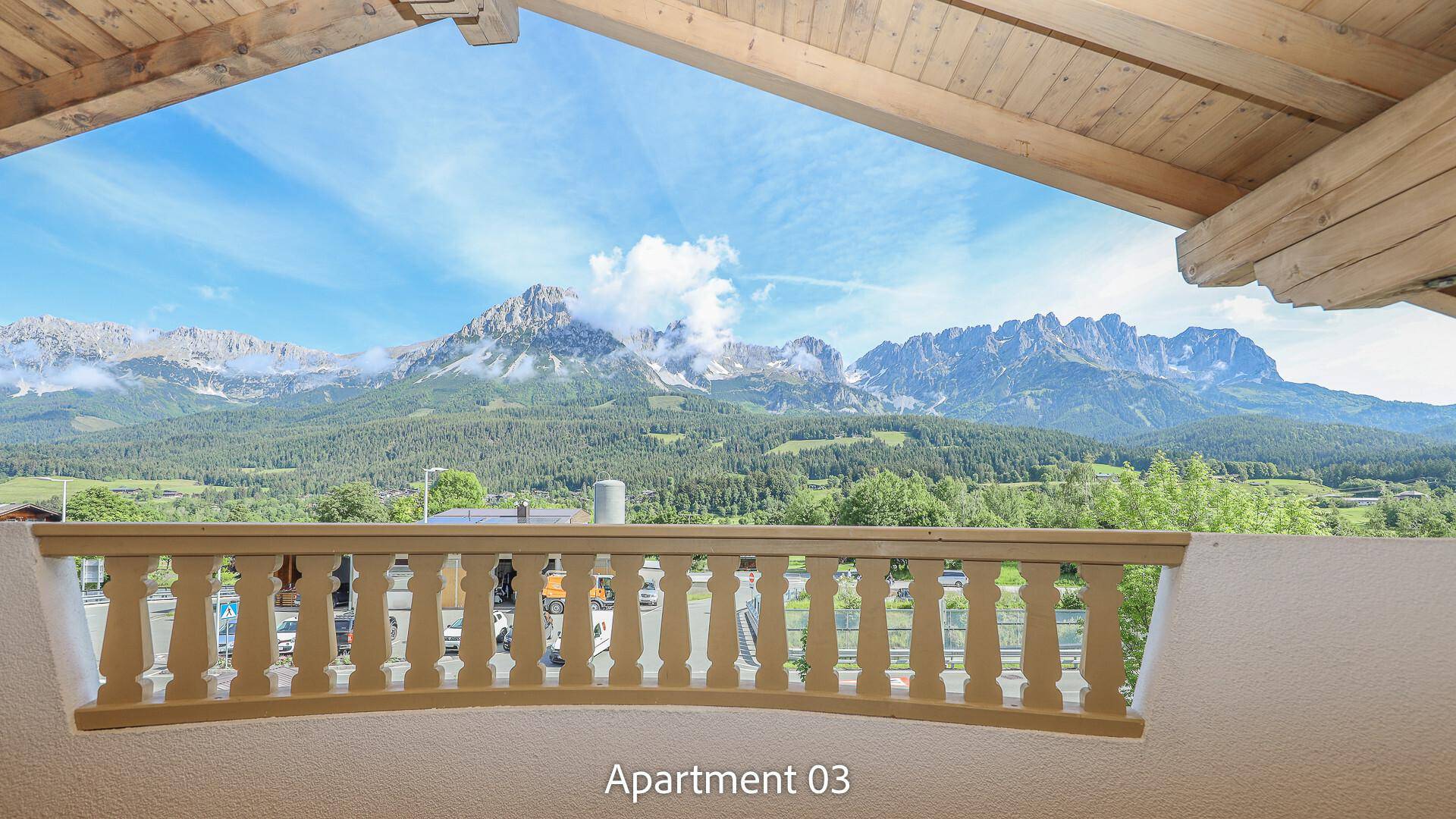 Balkon mit Holzgeländer und weitem Blick auf die beeindruckende Berglandschaft.