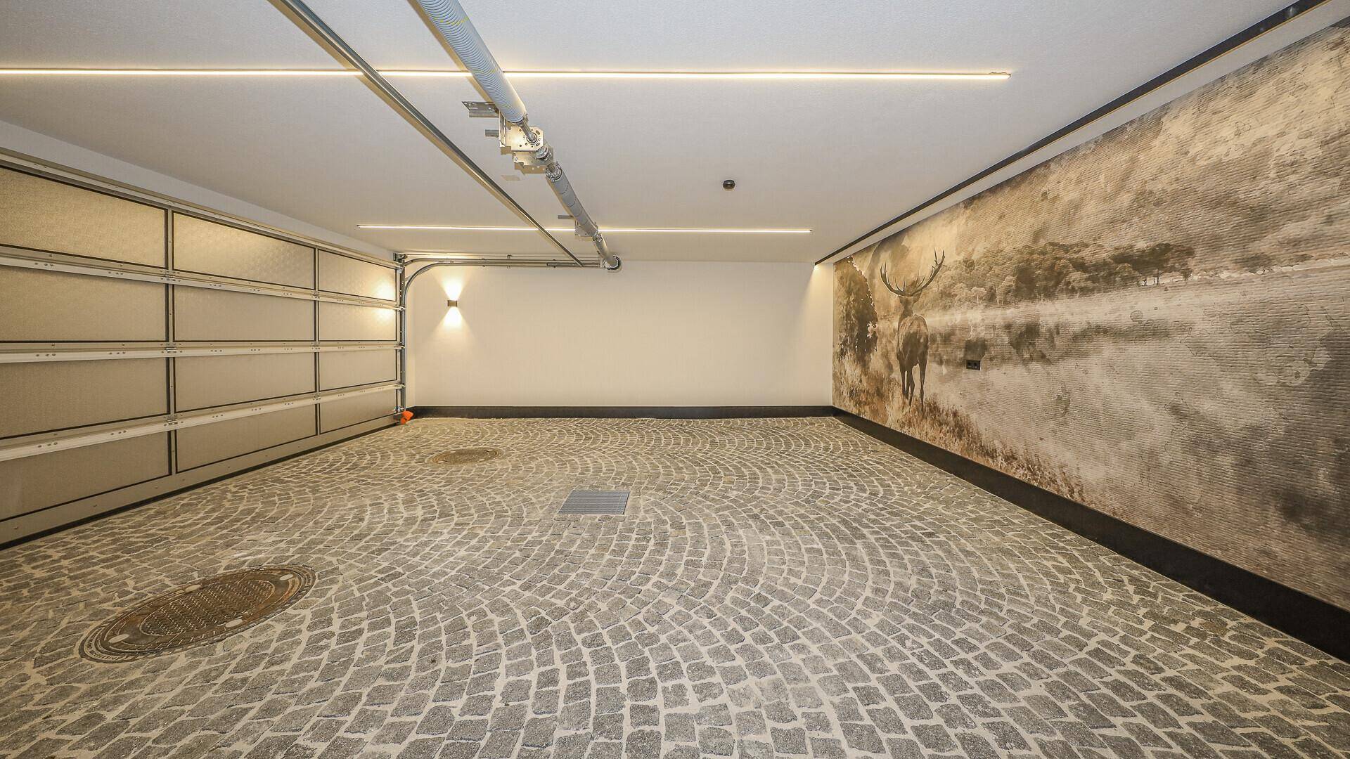 Geräumige Tiefgarage mit Pflastersteinboden und dekorativer Wandgestaltung.