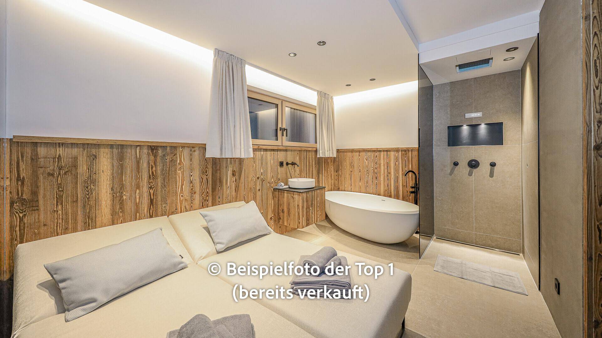 Geräumiges Schlafzimmer mit Holzwänden, freistehender Badewanne und offener Dusche.