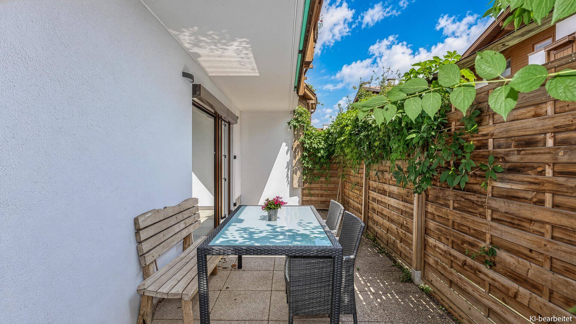 Gemütliche Terrasse mit Gartenmöbeln und Holzzaun, ideal für entspannte Stunden im Freien.