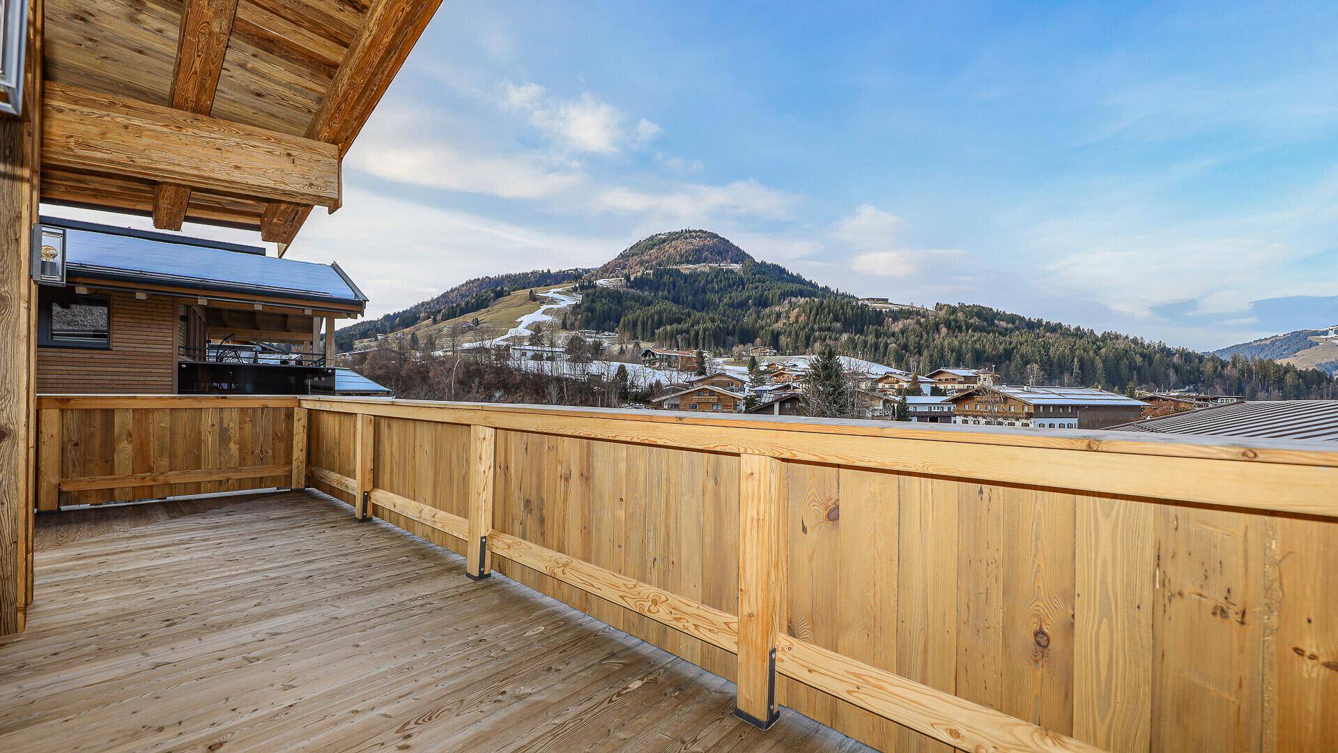 Großer Holzbalkon mit Bergblick und viel Platz zum Entspannen im Freien.