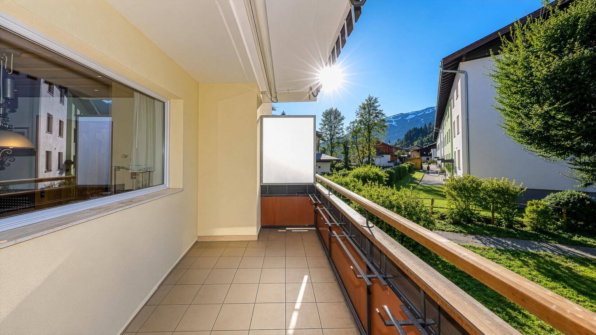 Sonniger Balkon mit Fliesenboden und herrlichem Blick auf die Berge.