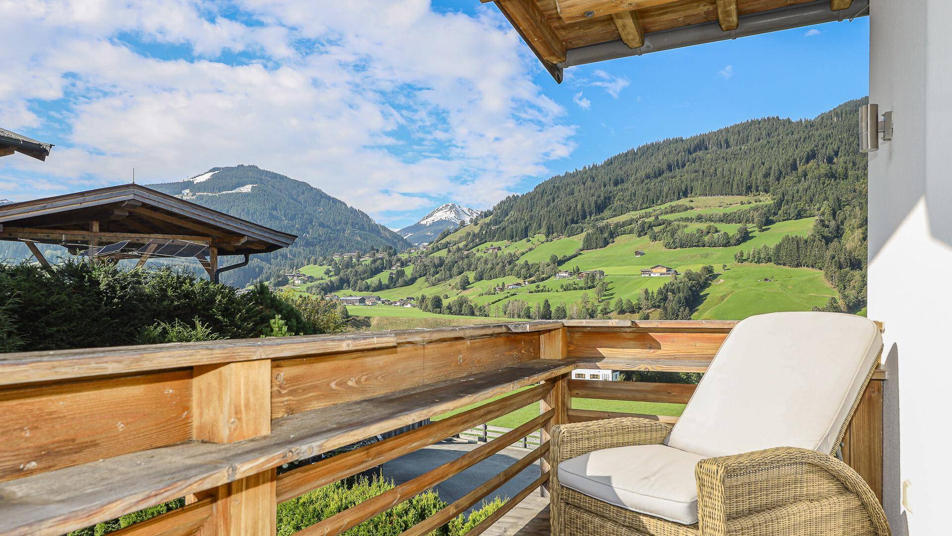 Gemütlicher Balkon mit Liegestuhl und atemberaubendem Blick auf die umliegende Berglandschaft.