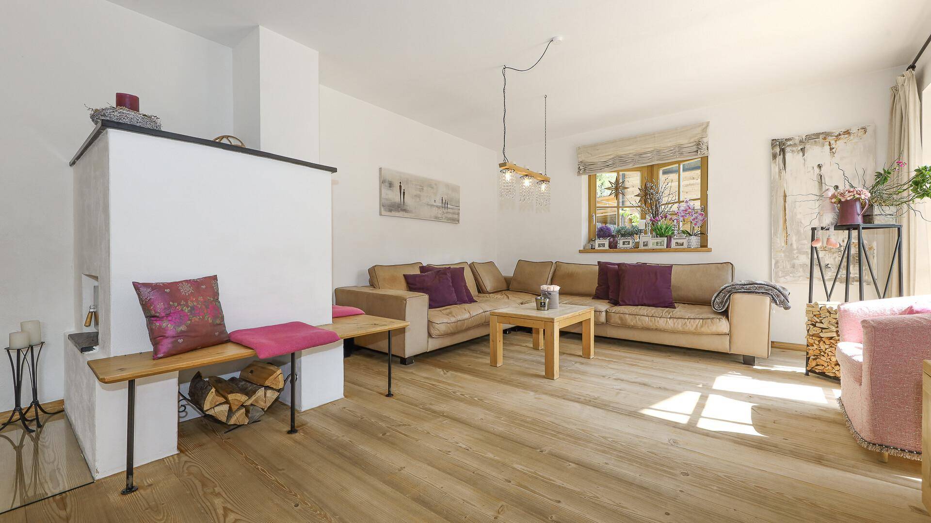 Gemütliches Wohnzimmer mit traditionellem Kachelofen, Holzboden und bequemer Sitzecke.