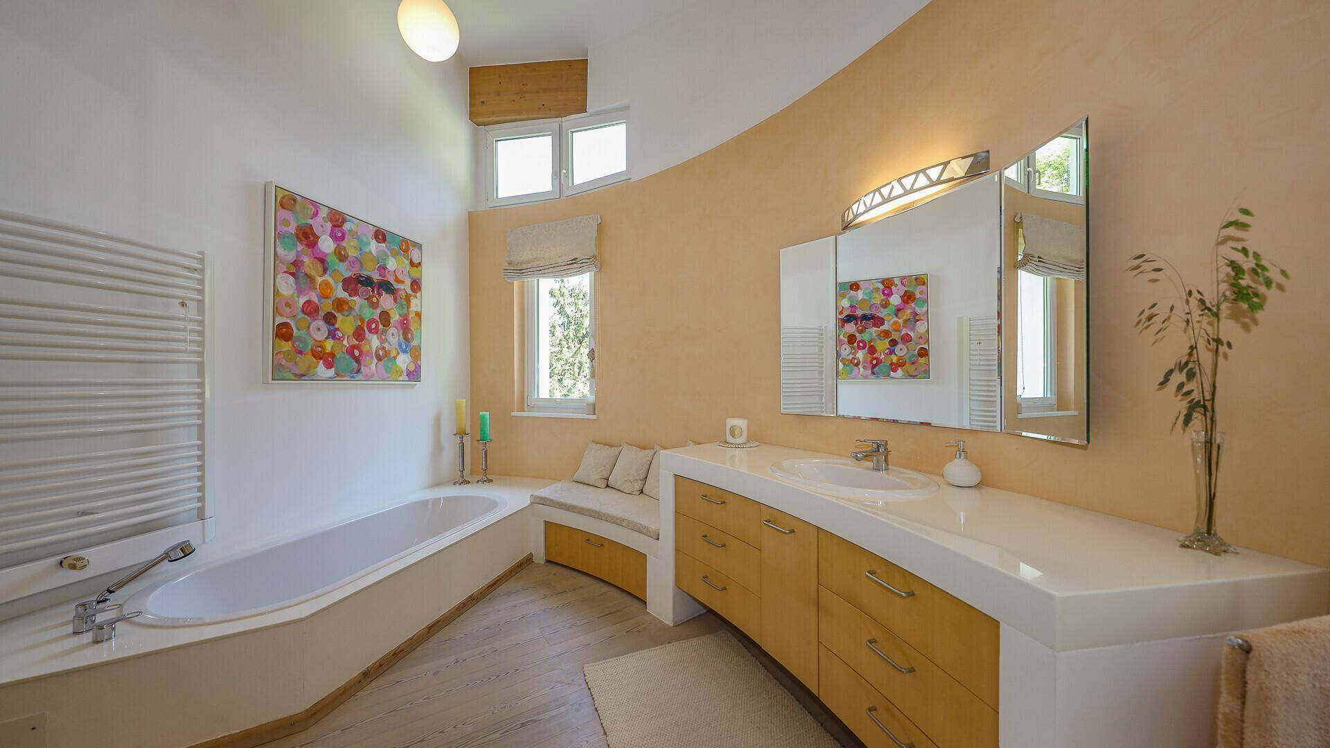 Geräumiges Badezimmer mit Badewanne, großem Waschtisch und Fenster für natürliche Belüftung.