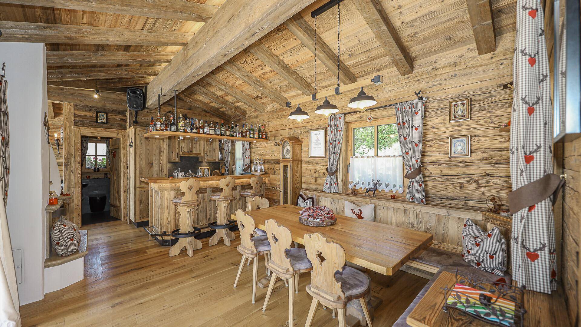 Geräumiger Essbereich im Holzhaus mit großer Bar, Holztisch und traditioneller Einrichtung.