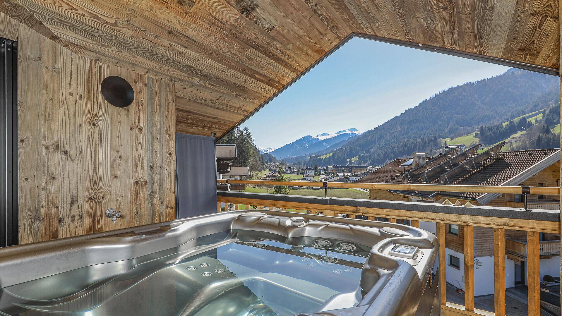 Balkon mit Whirlpool und atemberaubendem Blick auf die umliegende Berglandschaft.