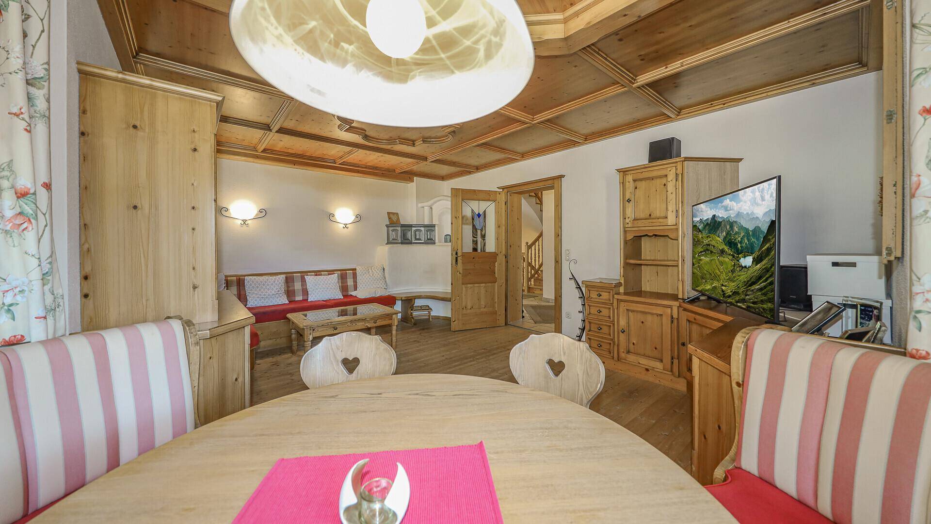 Heller Wohn-Essbereich im Landhausstil mit Holzbalkendecke und traditionellen Holzmöbeln.