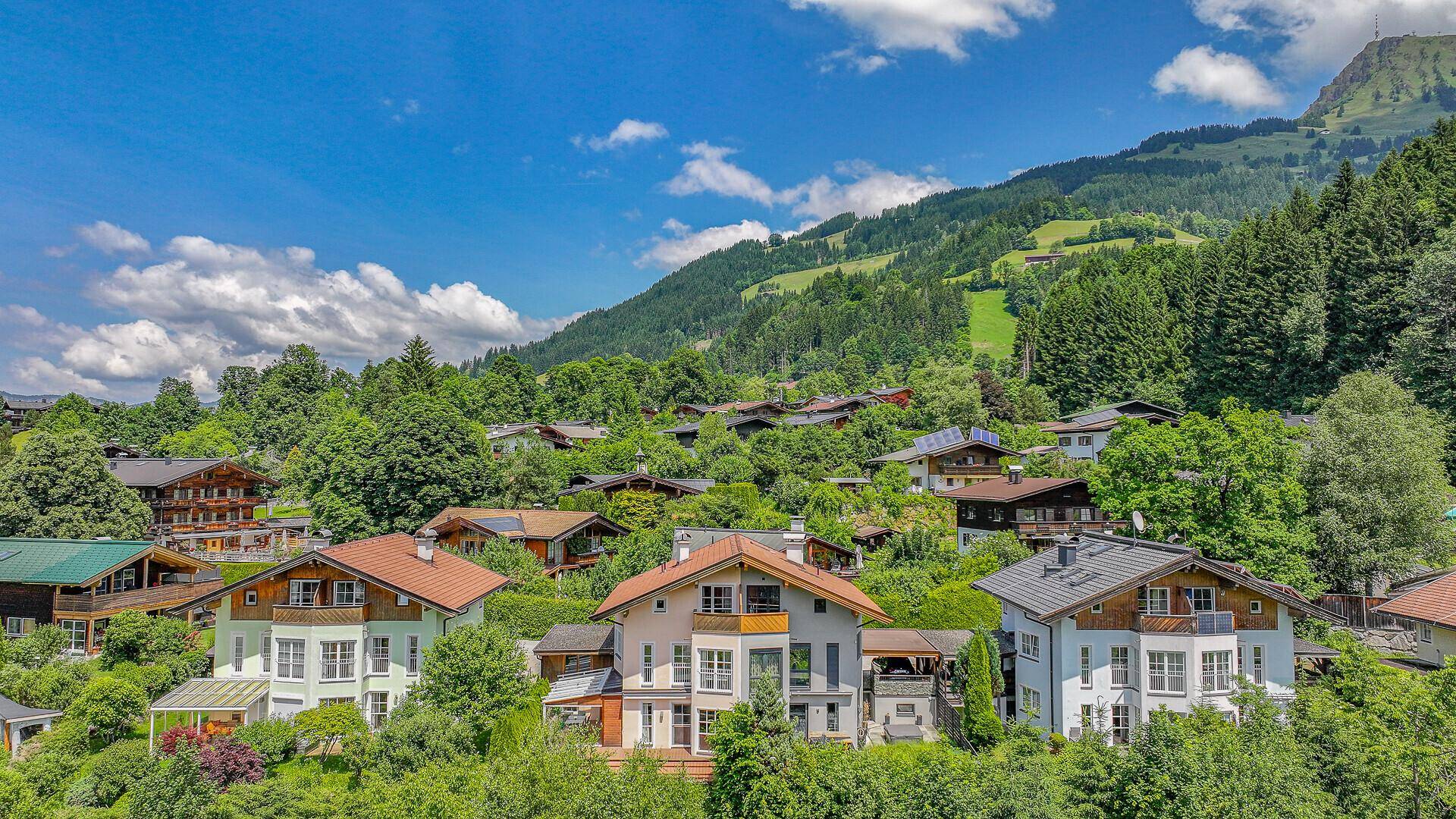 Malerische Siedlung am Berghang mit traditionellen Häusern und üppiger grüner Umgebung.