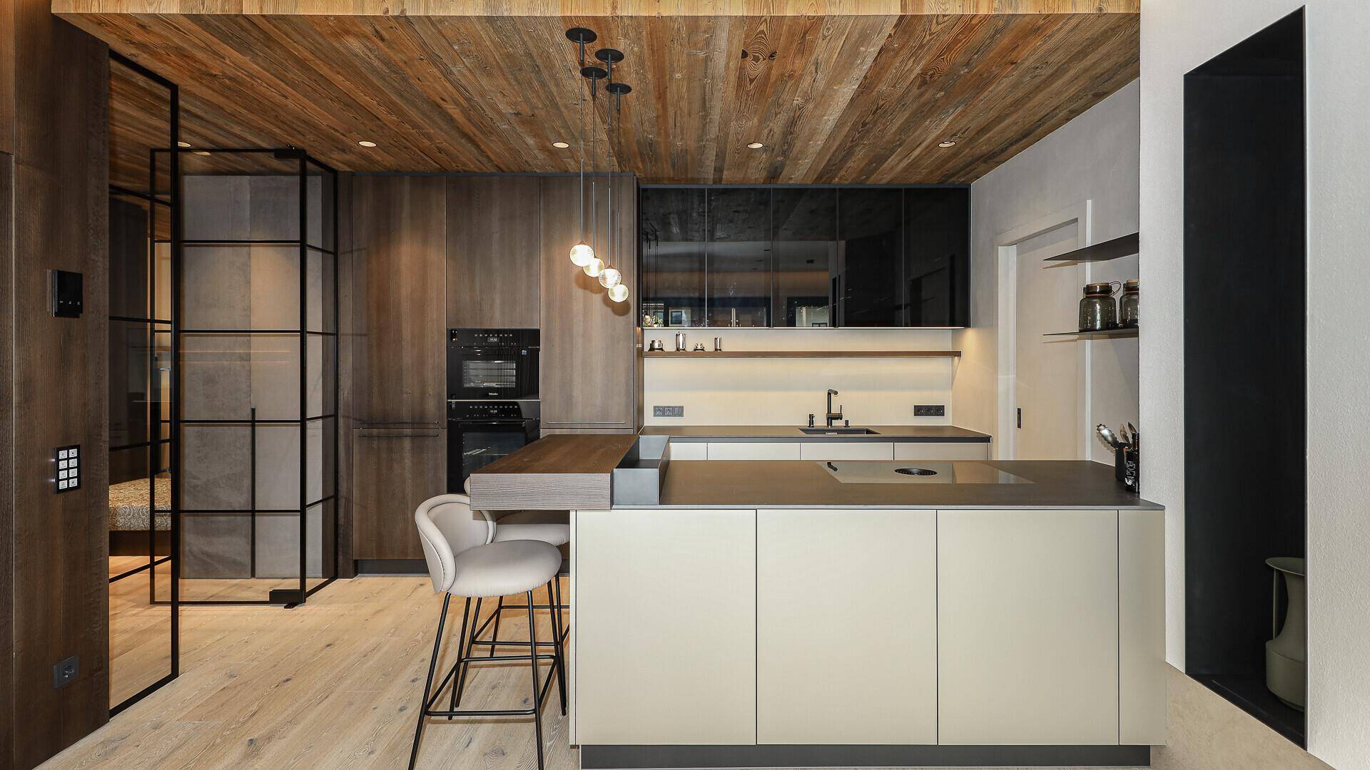 Moderne Küche mit Holzdecke, integrierten Geräten und einer Kücheninsel mit Barhockern.