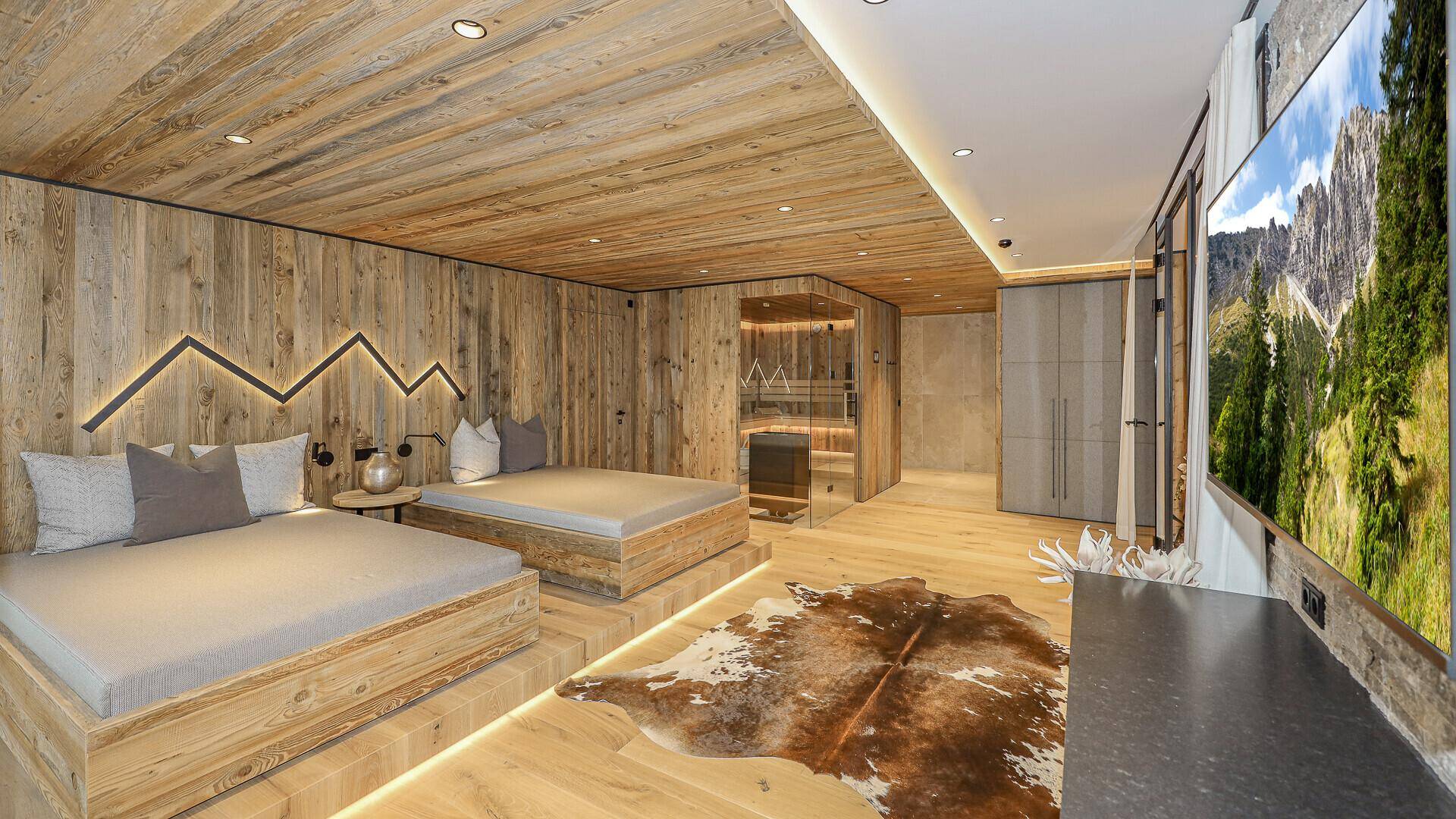 Luxuriöser Wellnessbereich mit Sauna, Liegeflächen und großem Bildschirm für Unterhaltung.