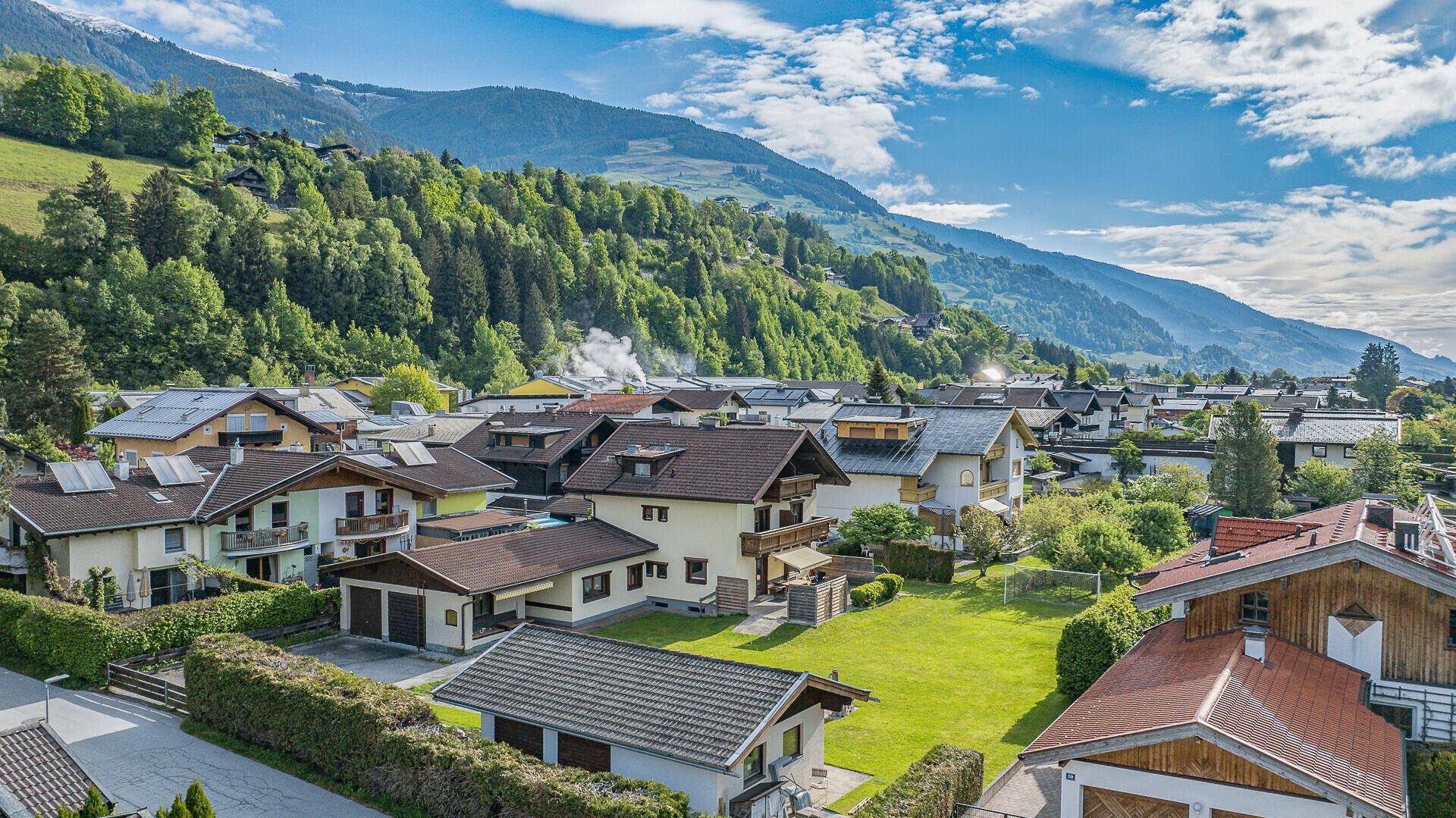 Panoramablick auf die Wohnsiedlung in einer grünen Berglandschaft mit vielen traditionellen Häusern.