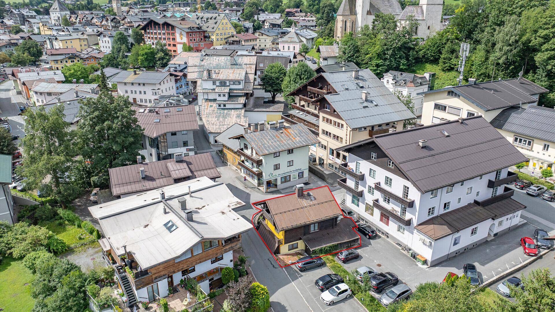 Vogelperspektive der Stadt mit einem rot umrandeten Gebäude und umliegenden Häusern.