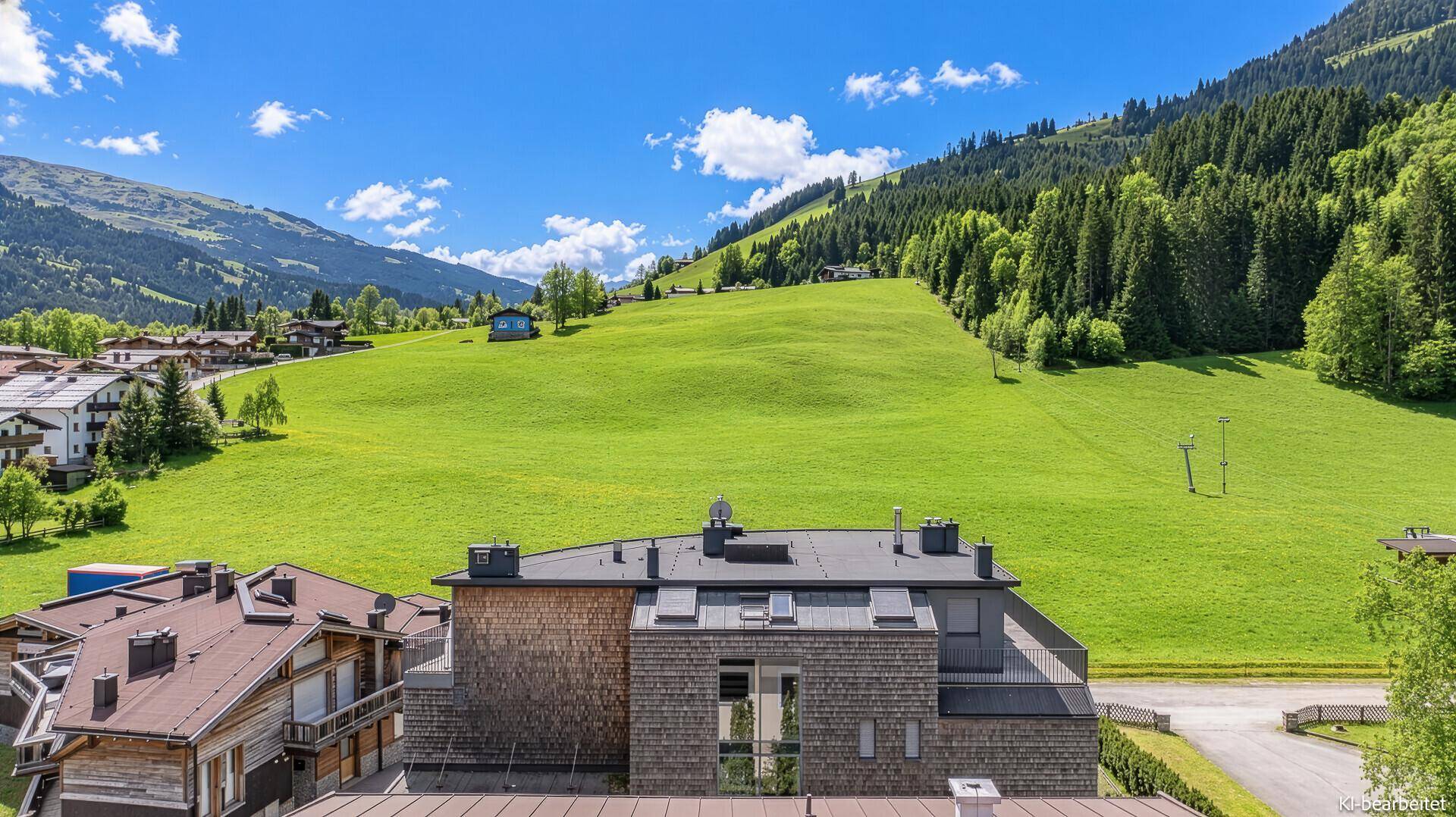 Panoramablick auf die grüne Berglandschaft mit modernen Gebäuden.