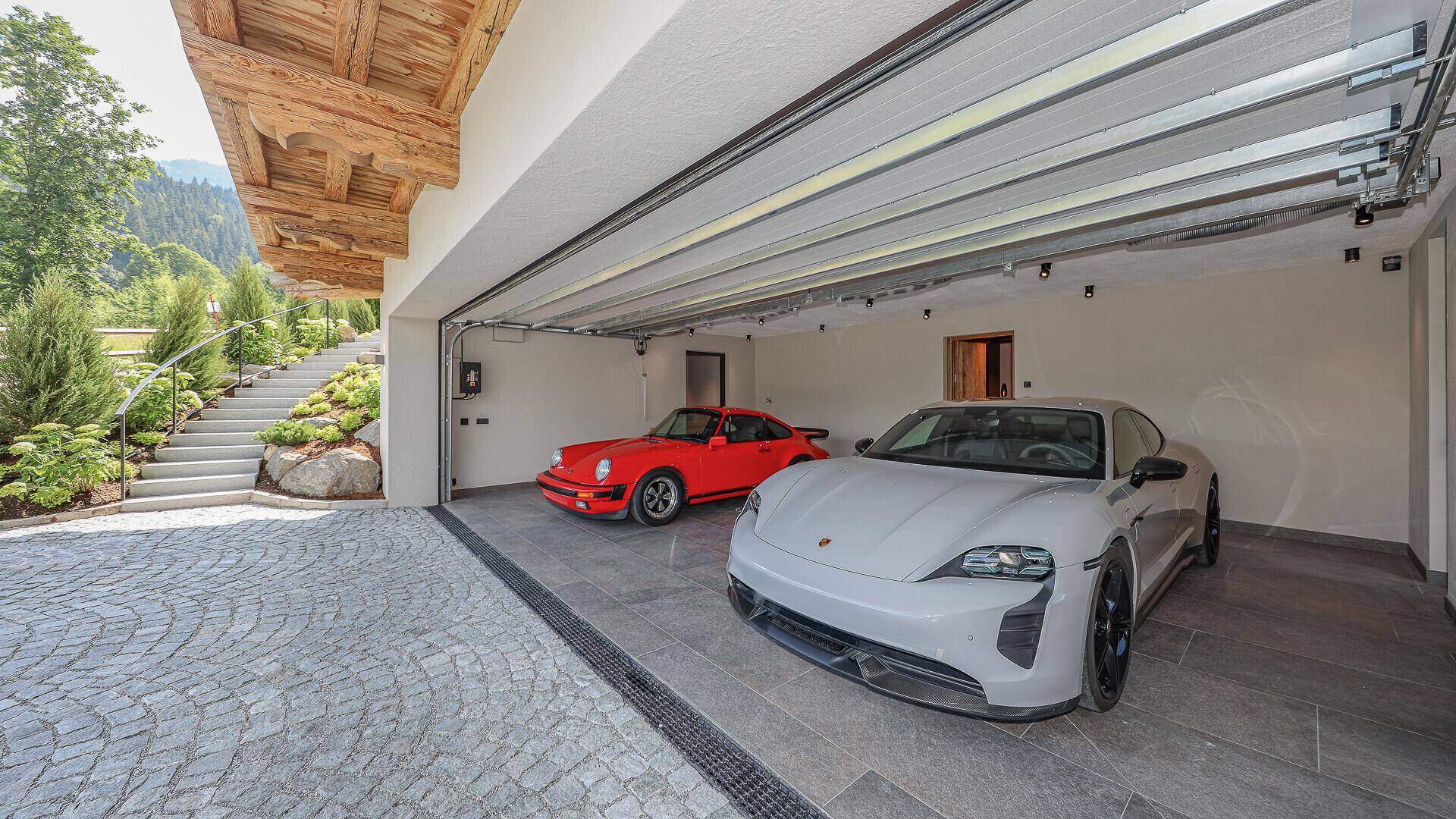 Geräumige Doppelgarage mit zwei Sportwagen und direktem Zugang zum Haus.