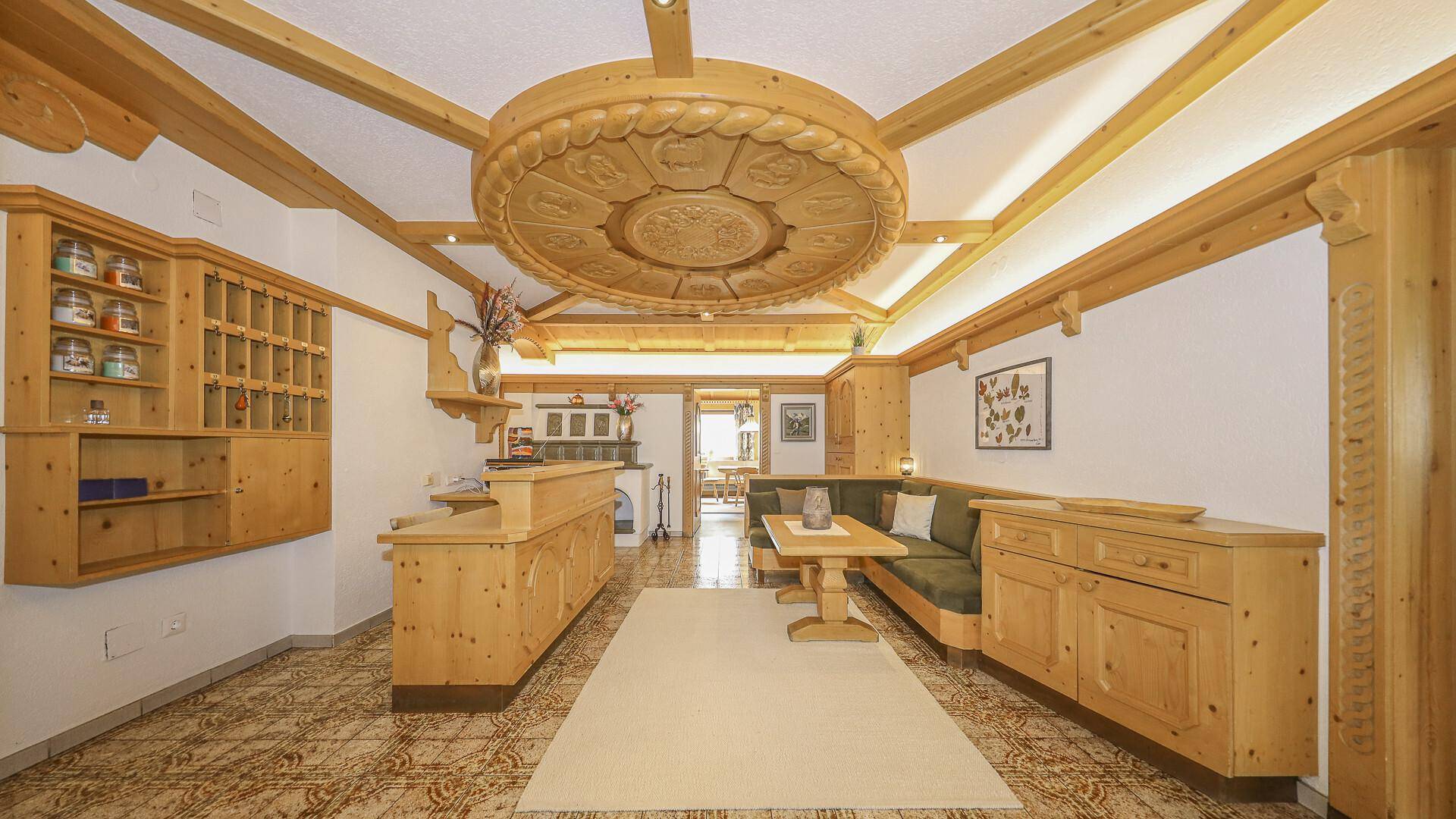 Traditioneller Empfangsbereich mit viel hellem Holz, dekorativer Decke und gemusterten Fliesenböden.
