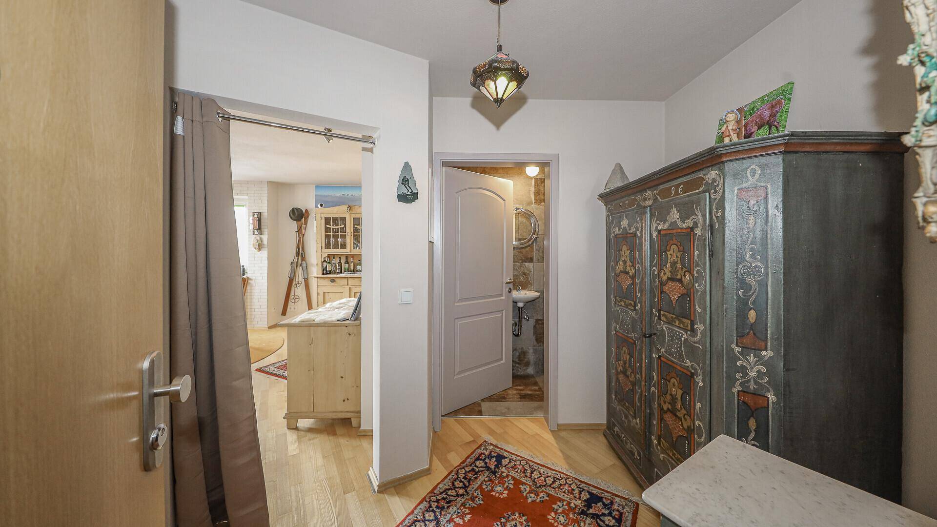 Flur mit Holzboden, traditionellem Schrank und Zugang zu weiteren Räumen.