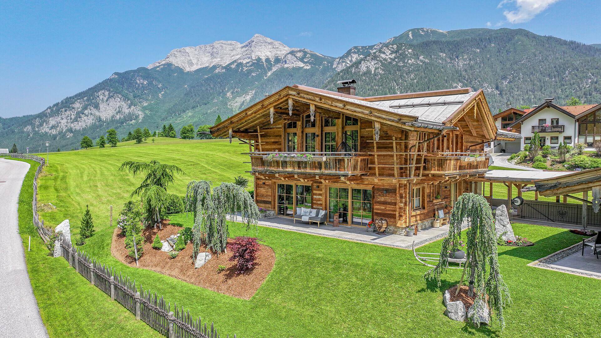 Großes Chalet in alpiner Umgebung mit Balkonen, großen Fenstern und Bergblick.