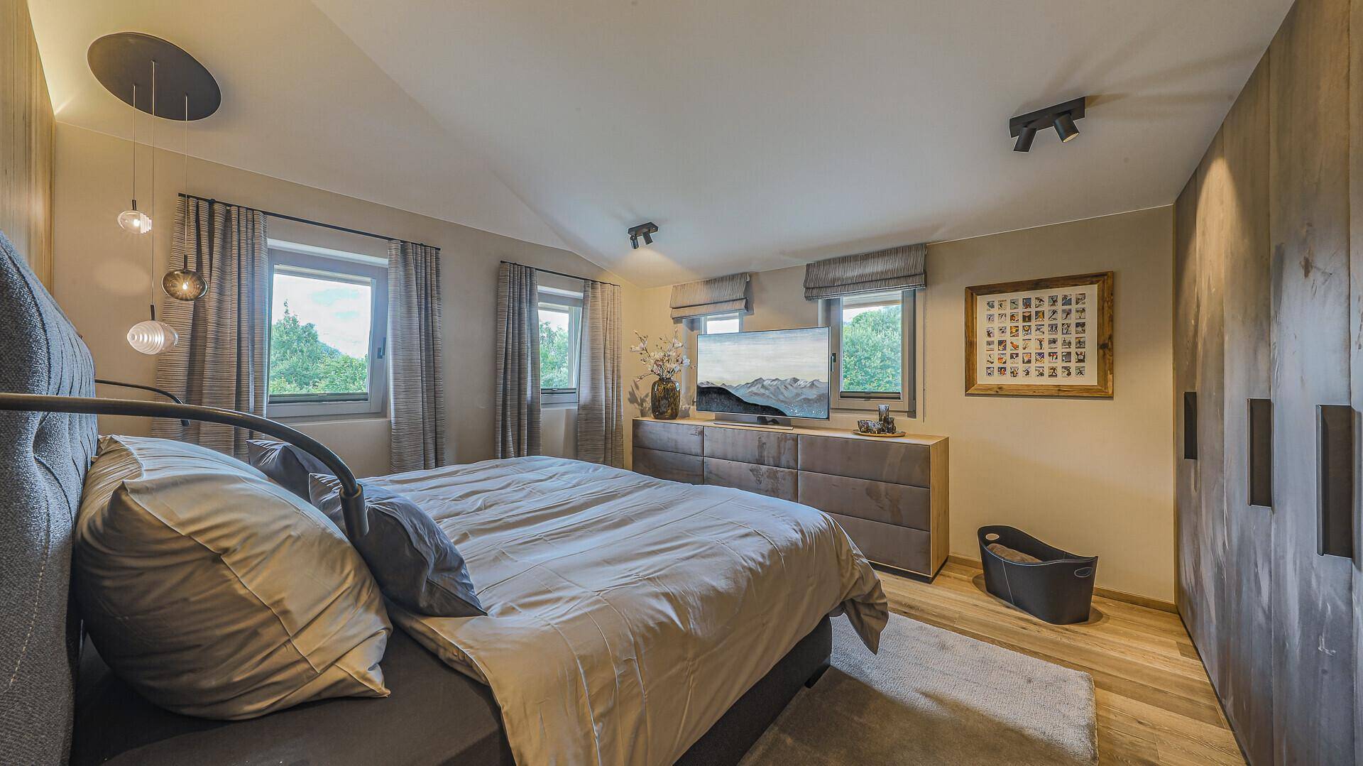 Gemütliches Schlafzimmer mit Doppelbett, Einbauschränken und Fenstern mit grüner Aussicht.