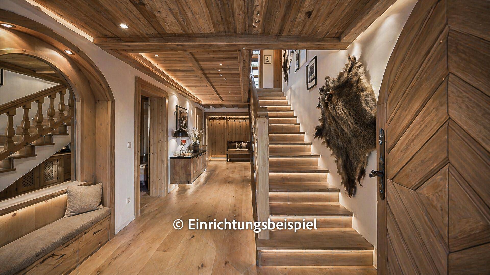 Modernisierter Eingangsbereich mit Holztreppe, Holzboden und indirekter Beleuchtung.