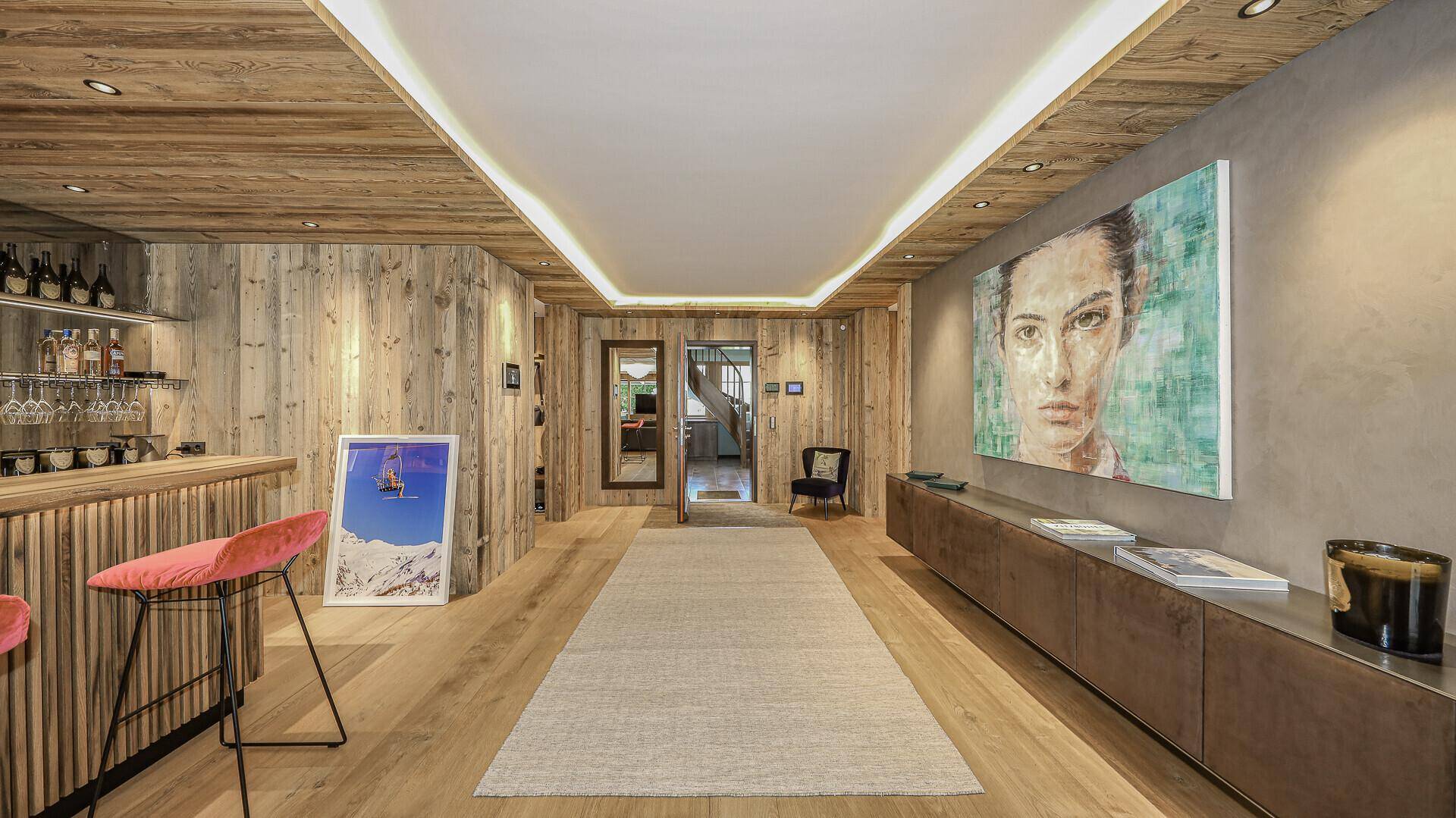 Langer Flur mit Holzwänden, Teppichläufer und moderner Kunst, der zu weiteren Räumen führt.