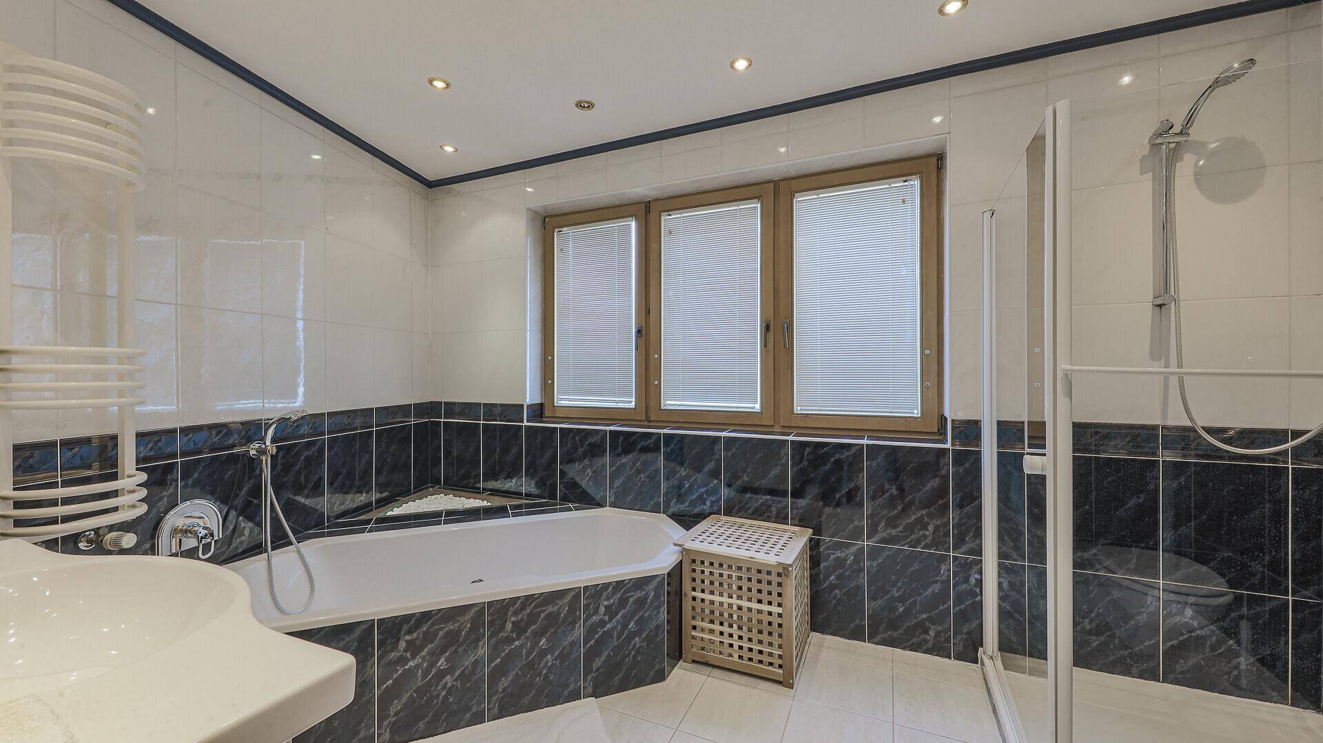 Geräumiges Badezimmer mit Badewanne, separater Dusche, Einzelwaschbecken und Fenster.